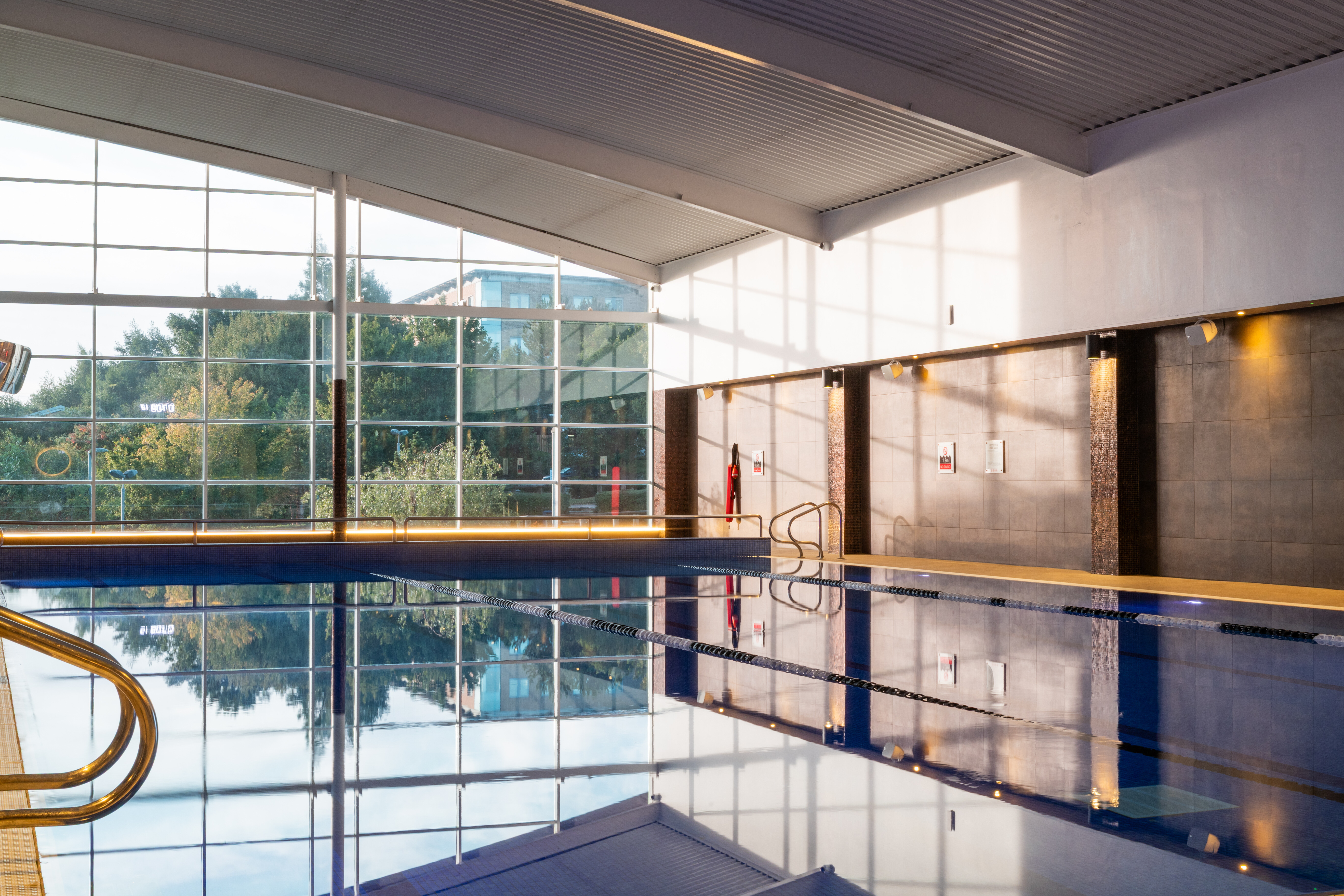 Reflections from a large window land in the spacious and airy pool room