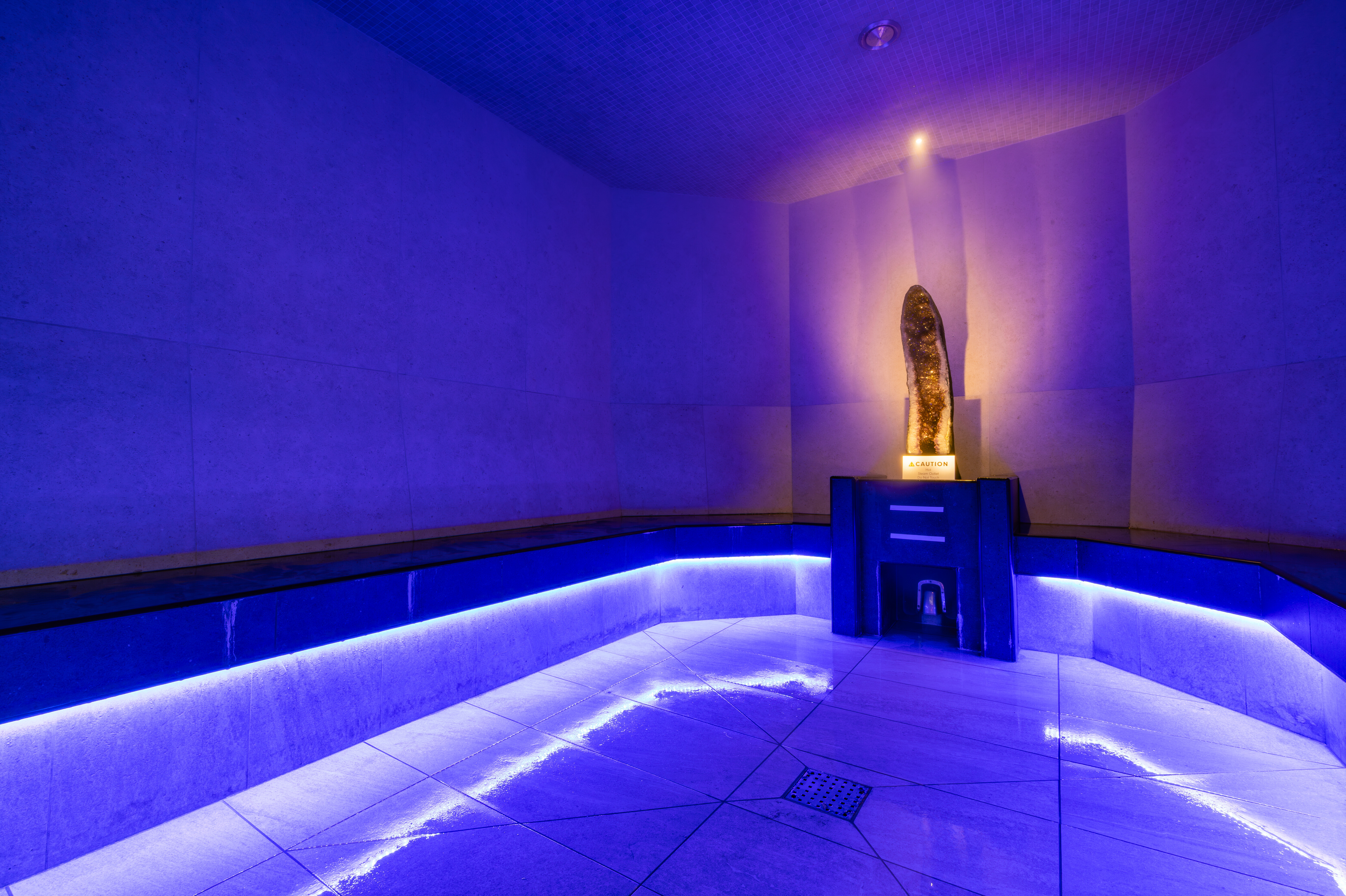 A half amethyst in the blue toned light of the crystal steam room