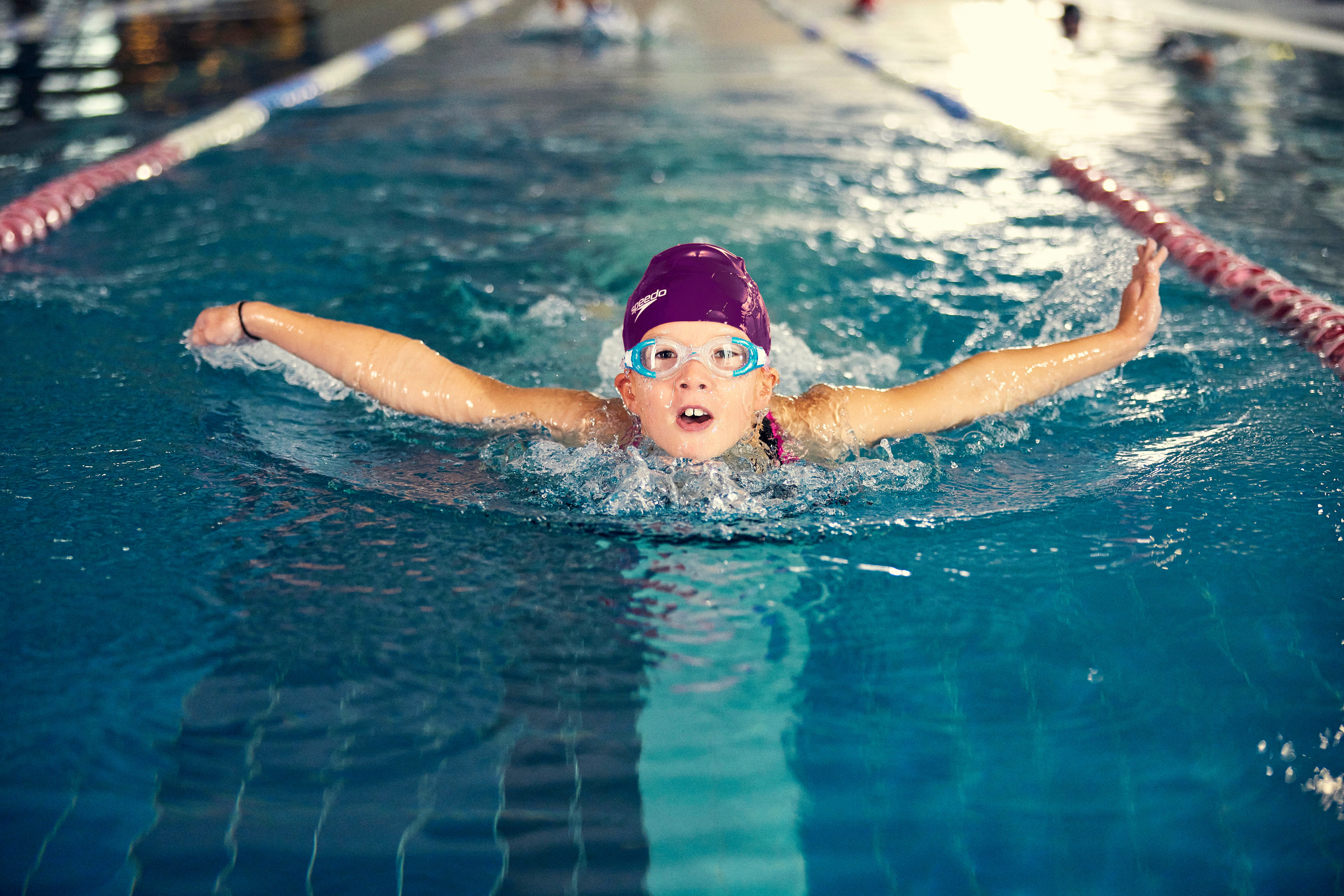 A child swimming butterfly in a lane of the pool