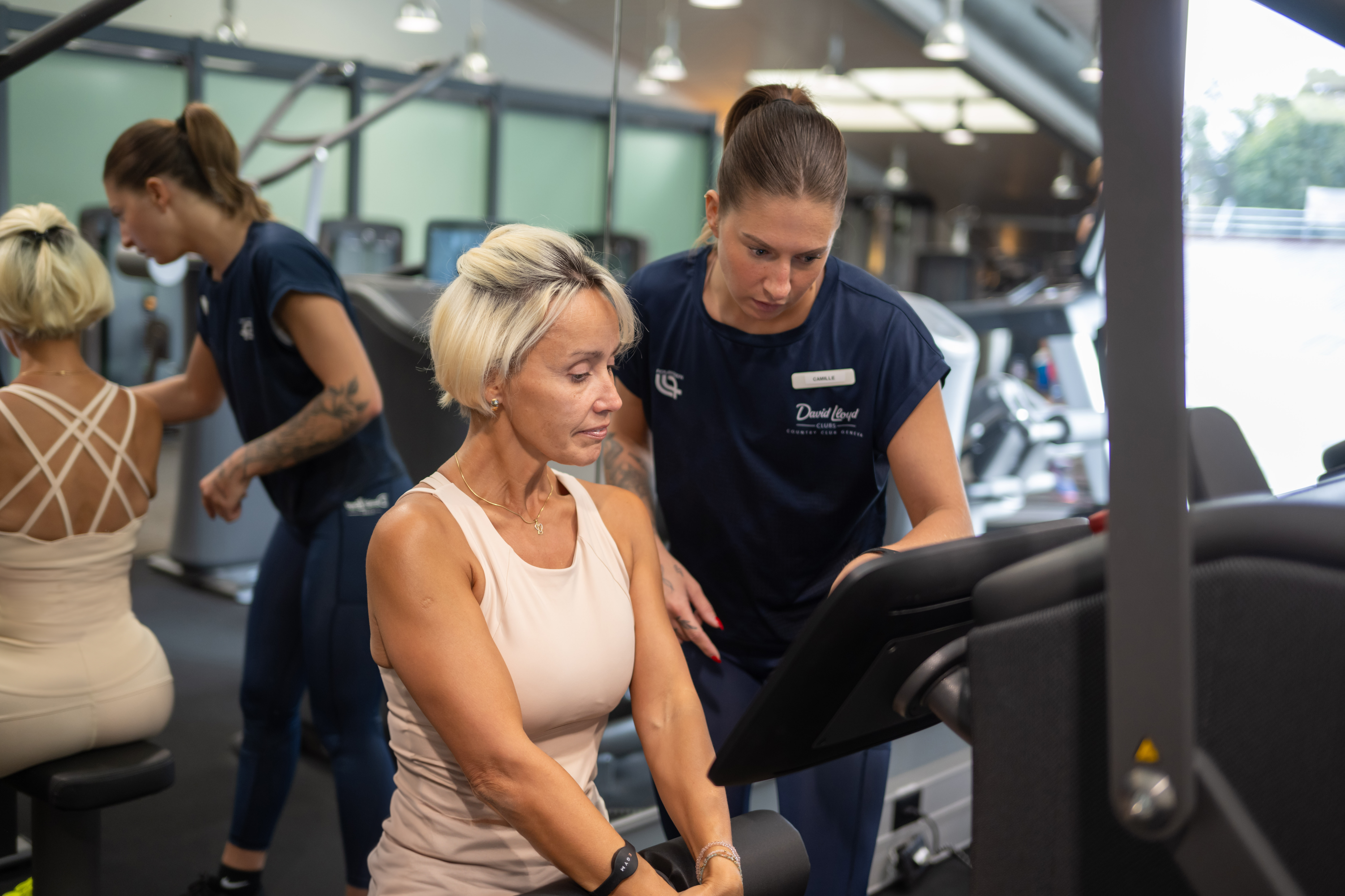 A personal trainer explaining the equipment to a woman