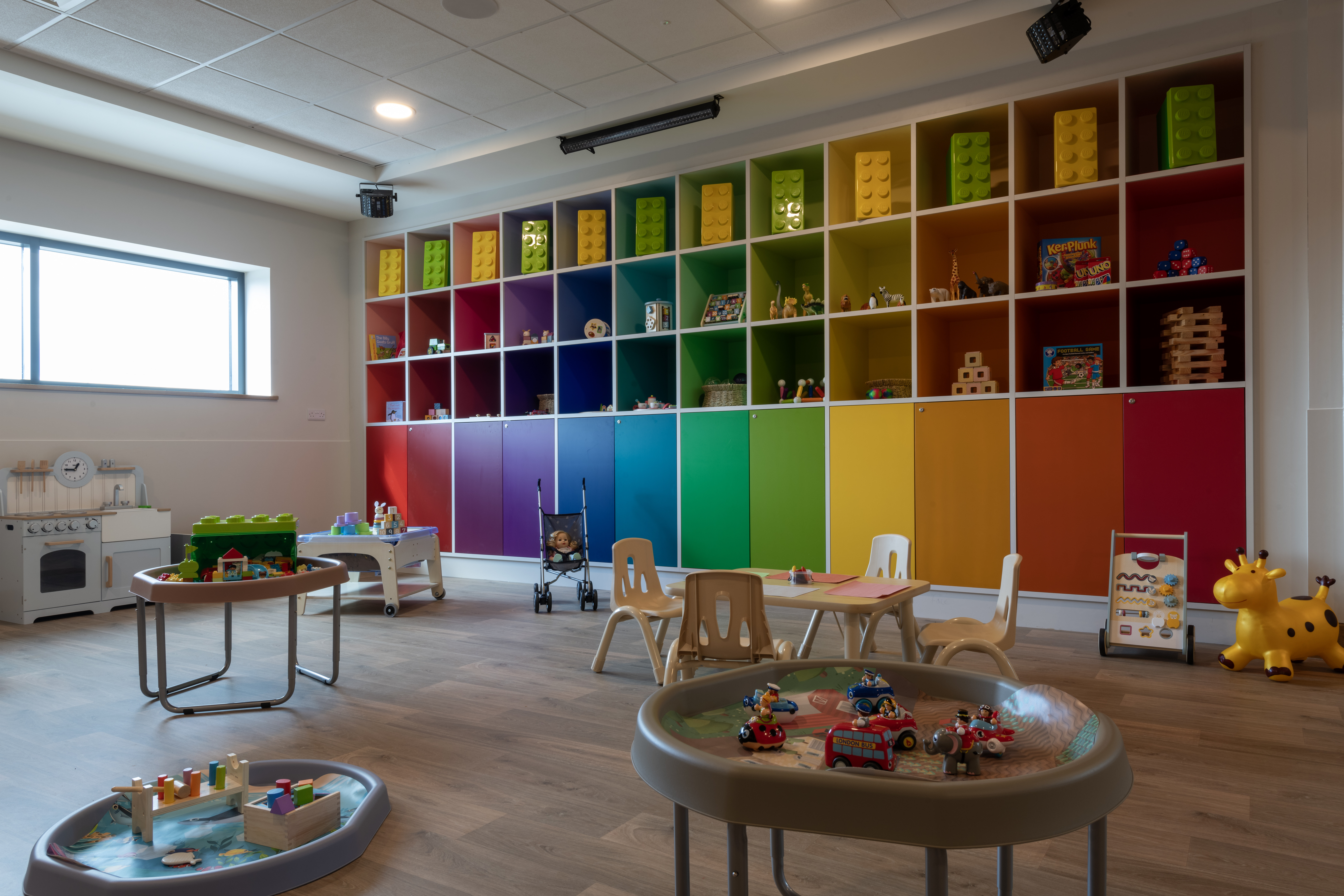 A bright and colourful room with child size tables set up