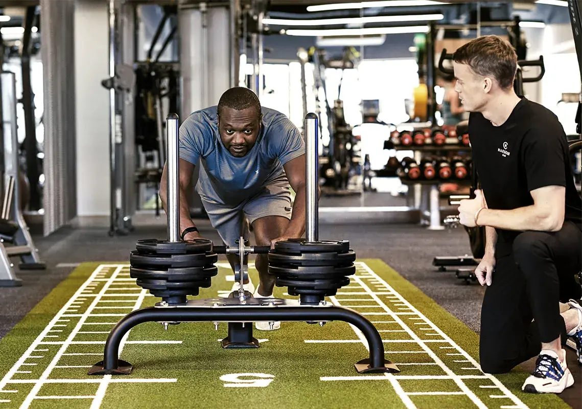 A man pushing a sled in the gym