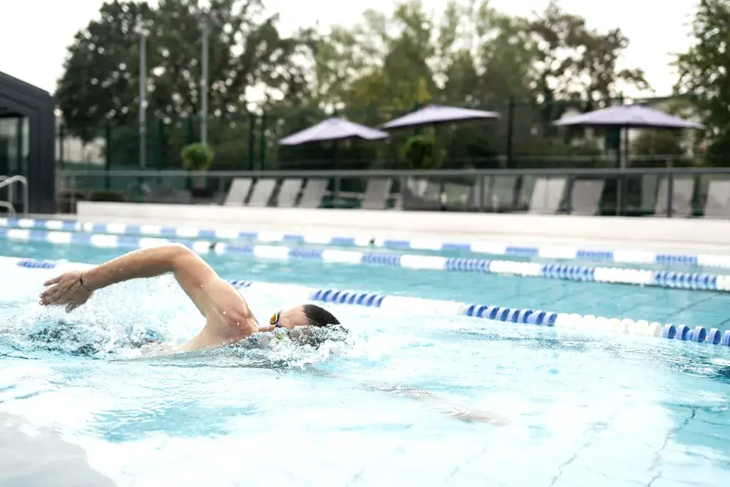 A man swimming in an outdoor pool at David Lloyd Clubs