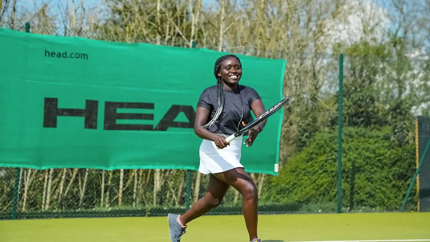 A woman playing tennis on a David Lloyd Clubs outdoor tennis court