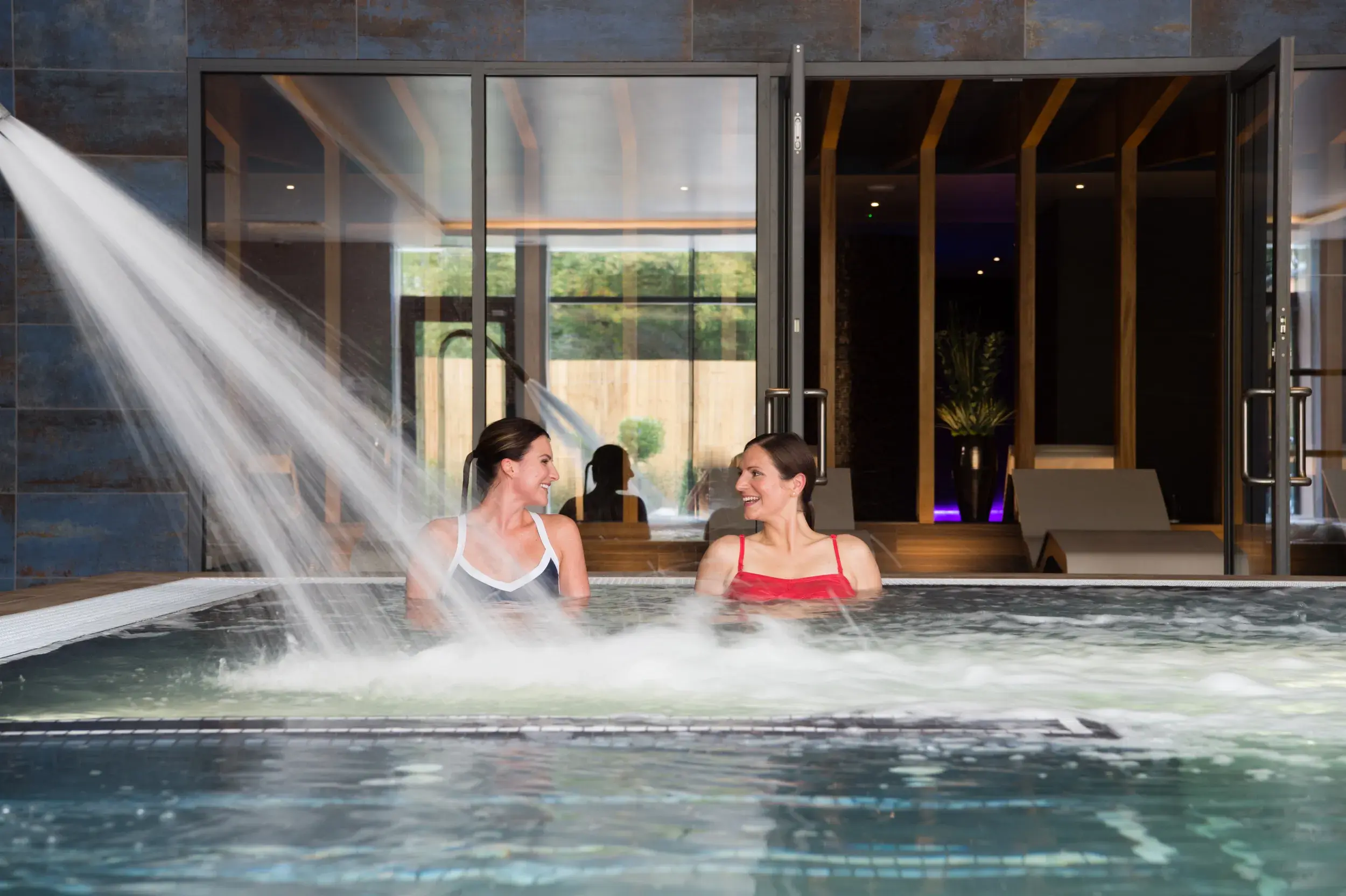 Two women in an outdoor spa pool
