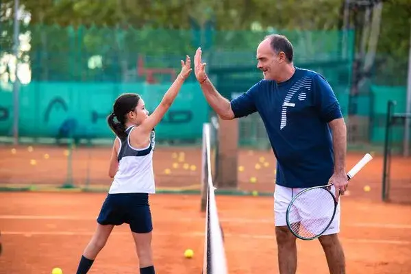 Children jumping holding tennis racquets