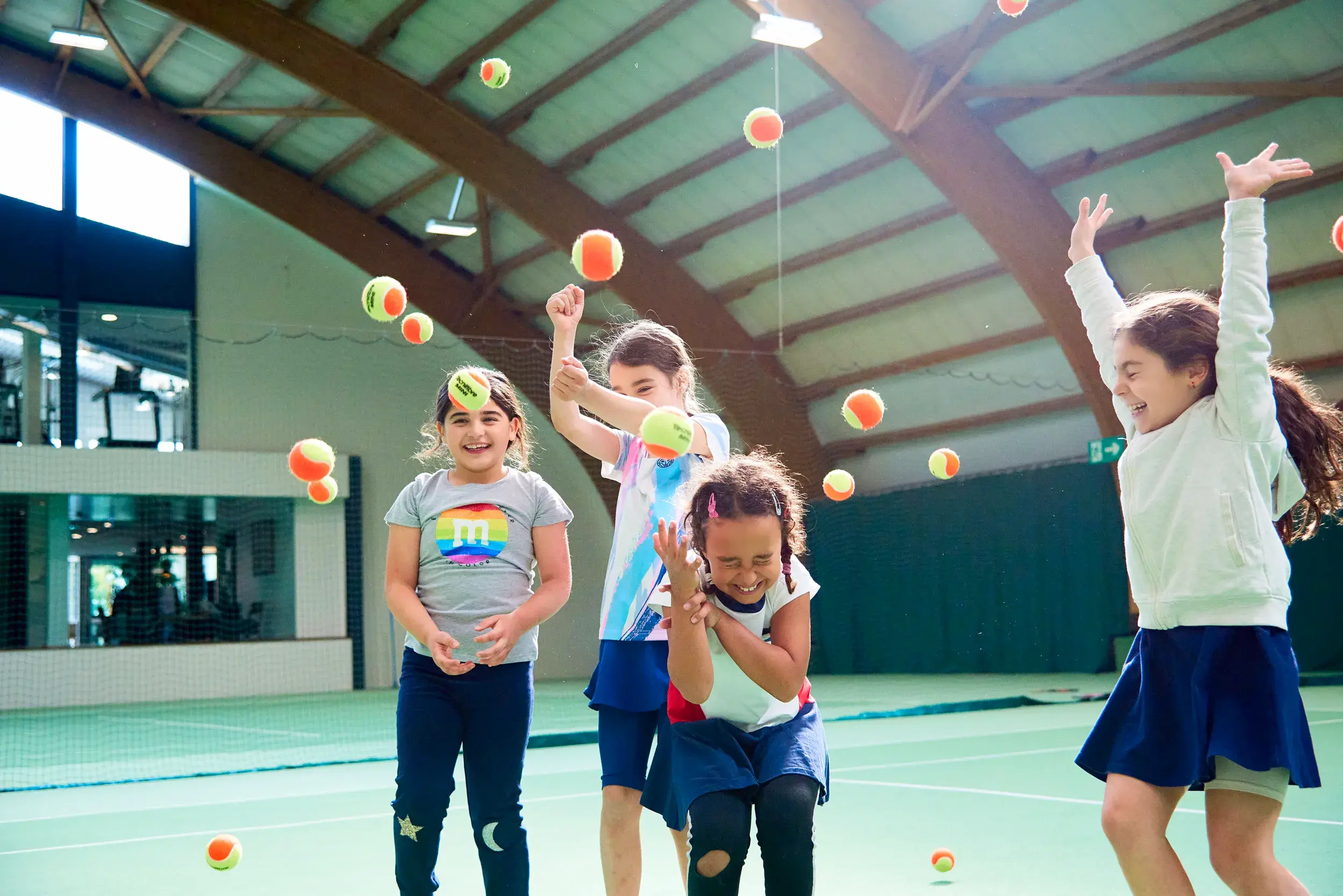 Children jumping holding tennis racquets
