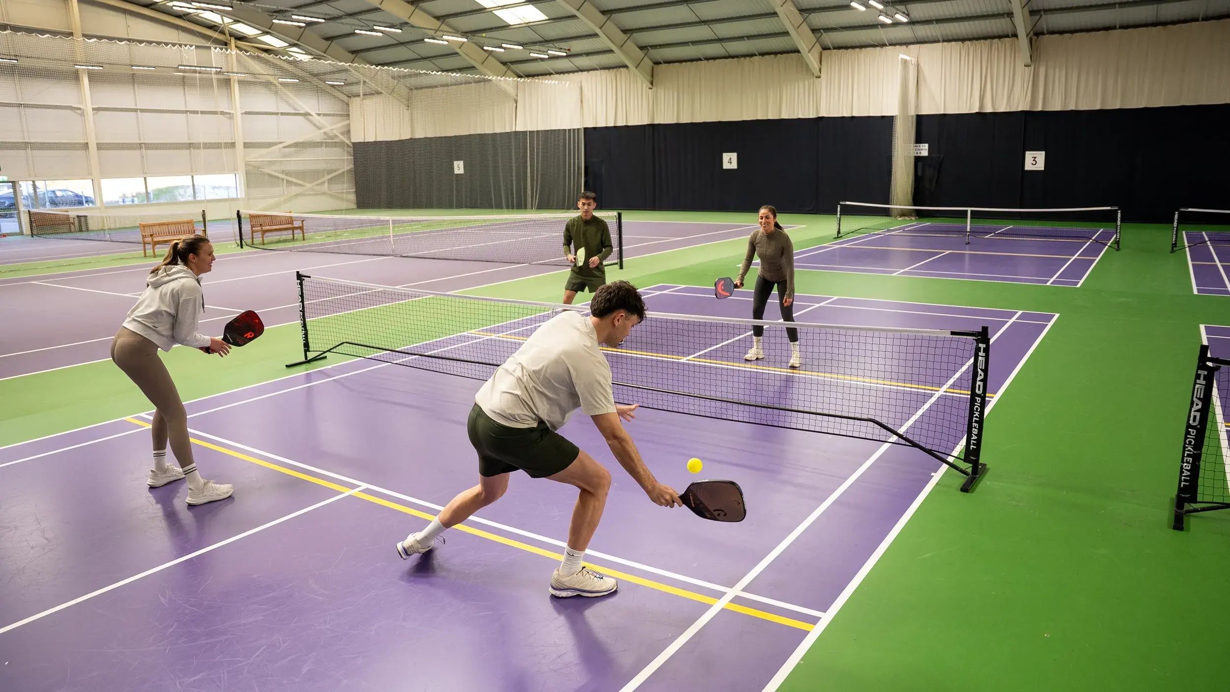 4 people playing pickle ball