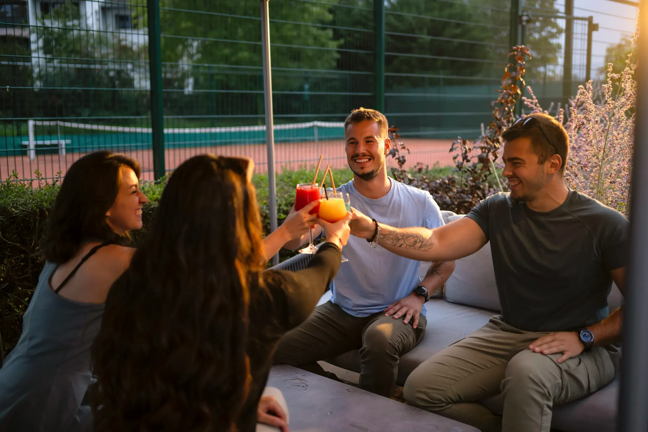 Two people sitting by the pool enjoying a drink