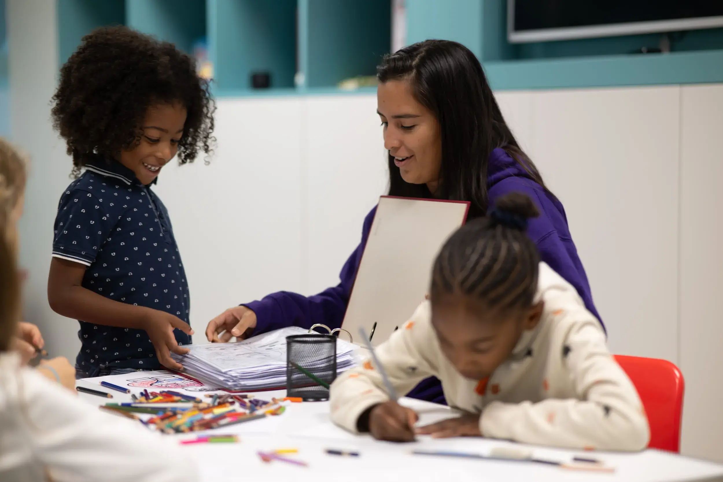 Children sitting round a table colouring