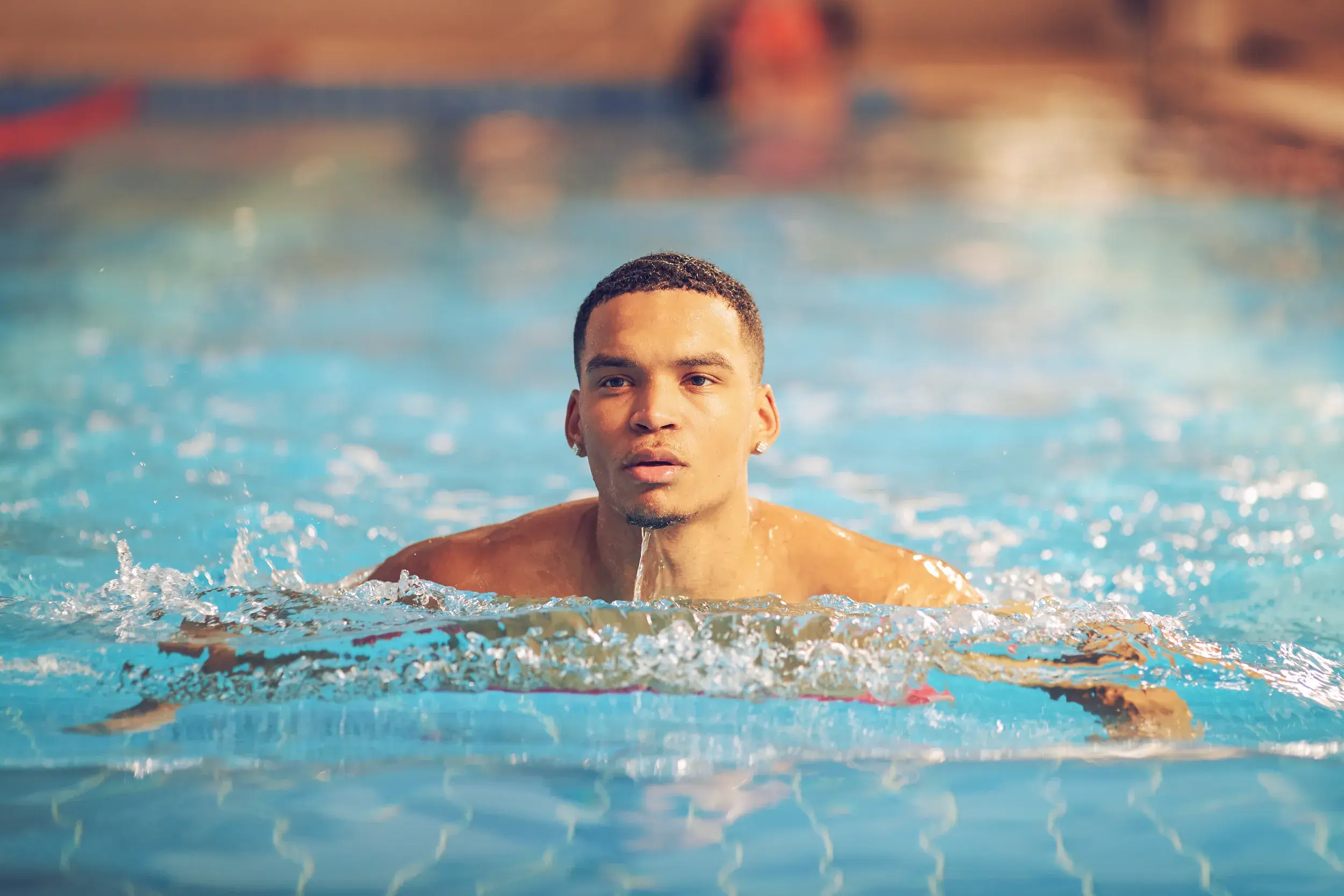 A man swimming in an indoor pool