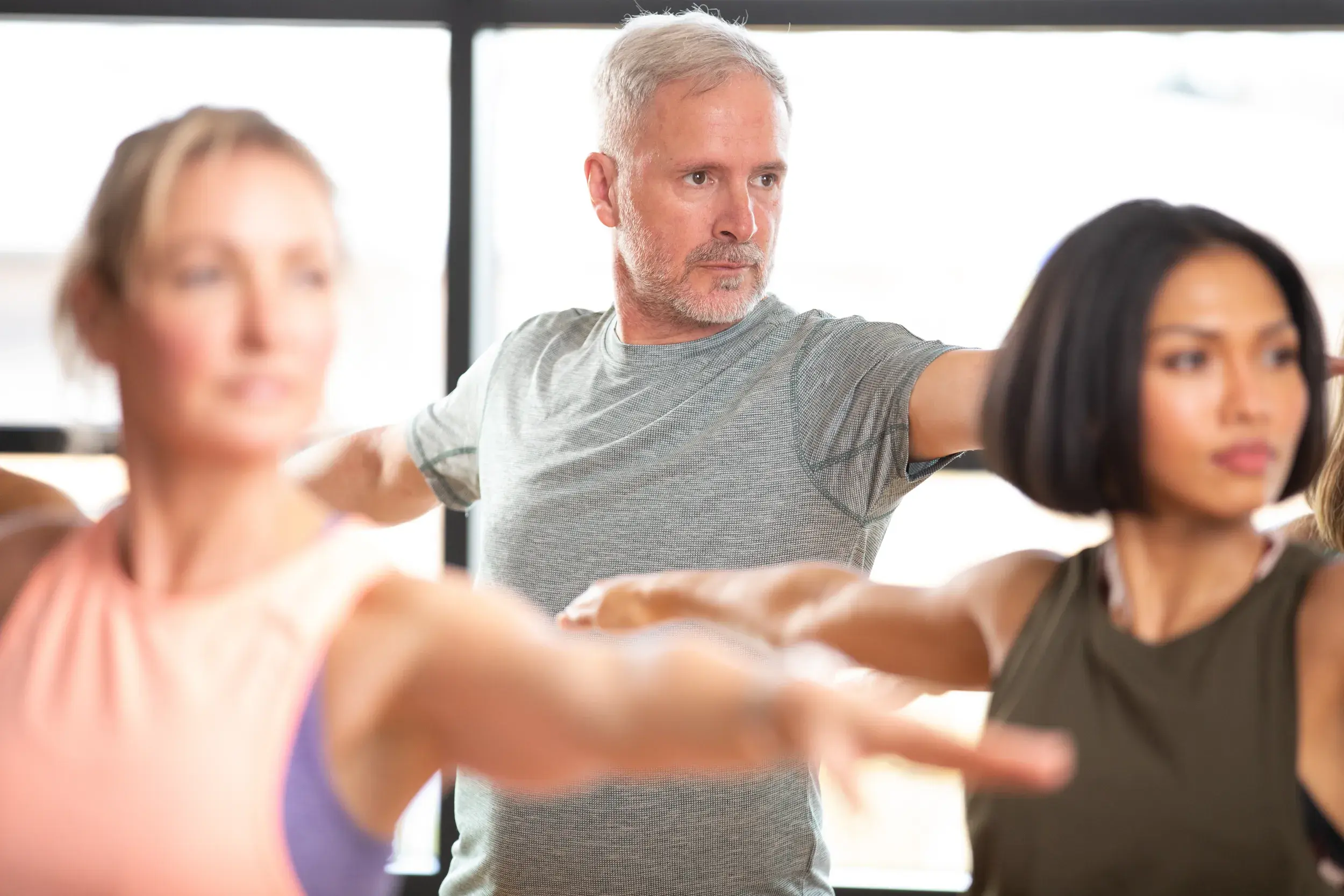 A yoga class holding the warrior pose.