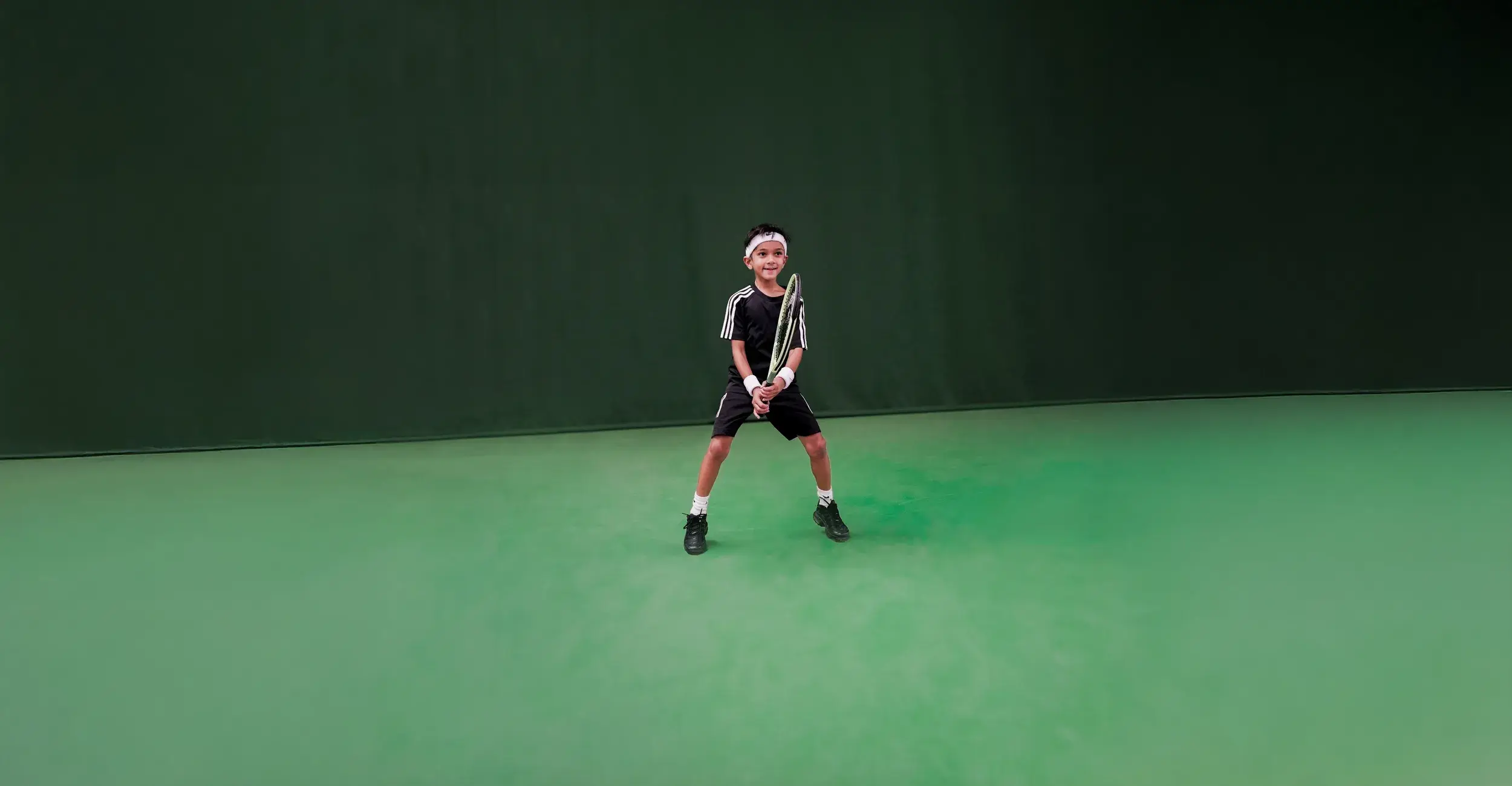 Children jumping holding tennis racquets
