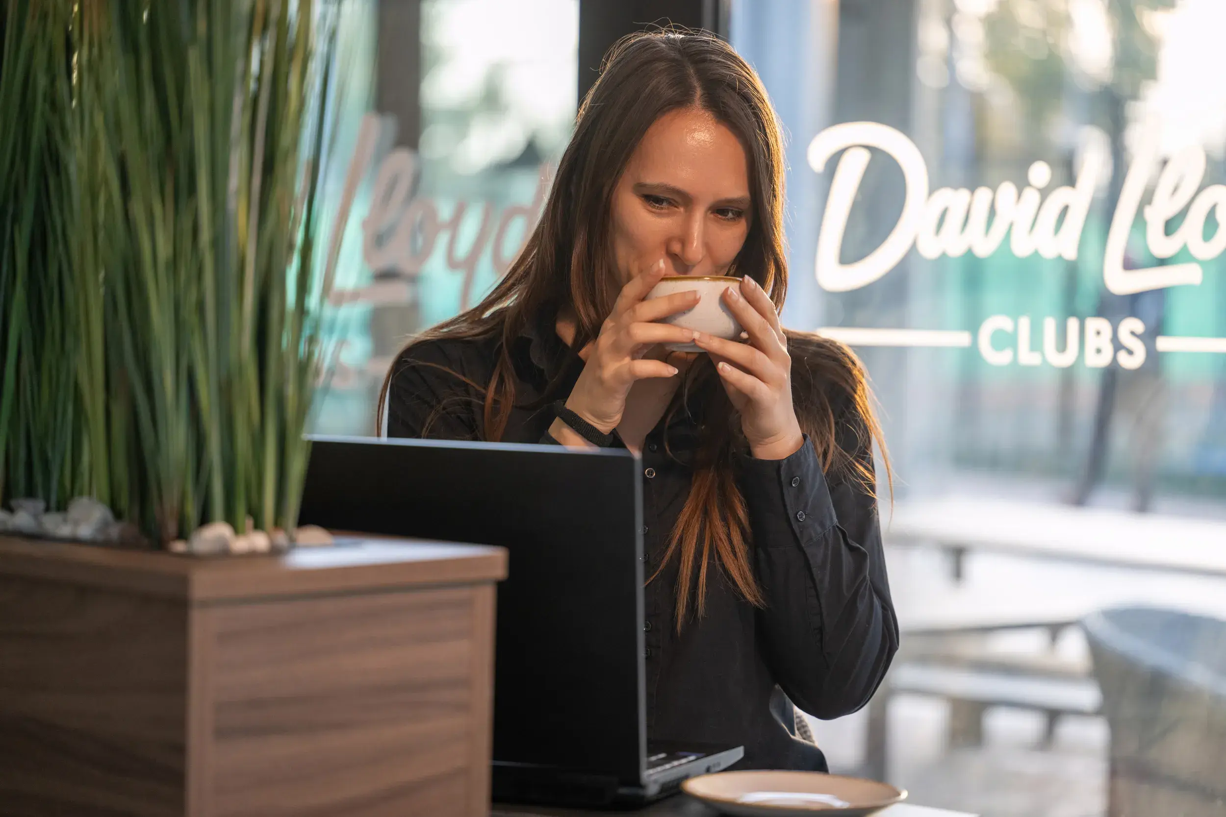 Woman working on a laptop drinking coffee