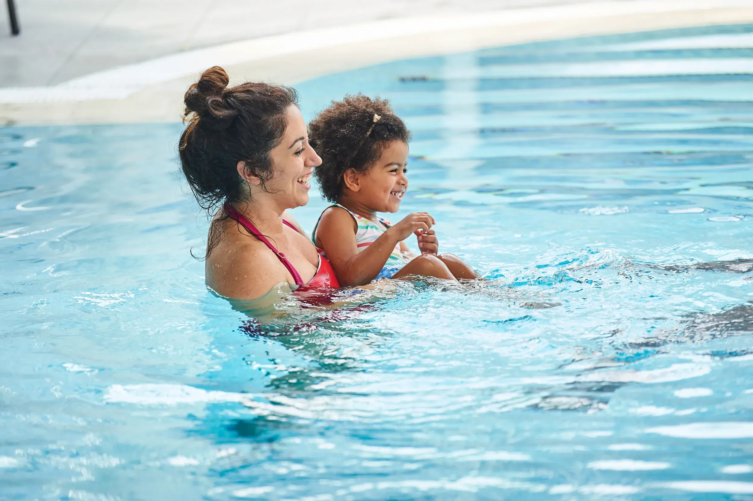 A woman and a toddler in a swimming pool.