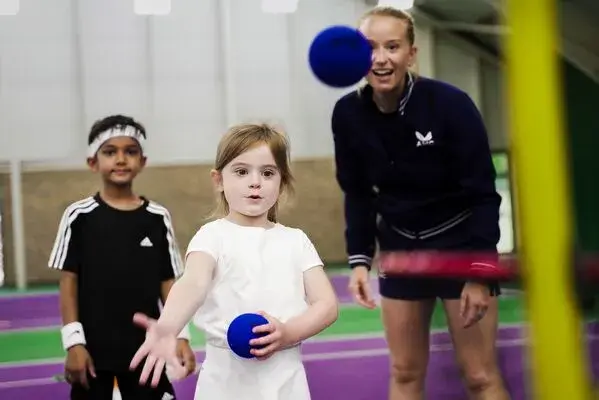 Children learning how to play tennis