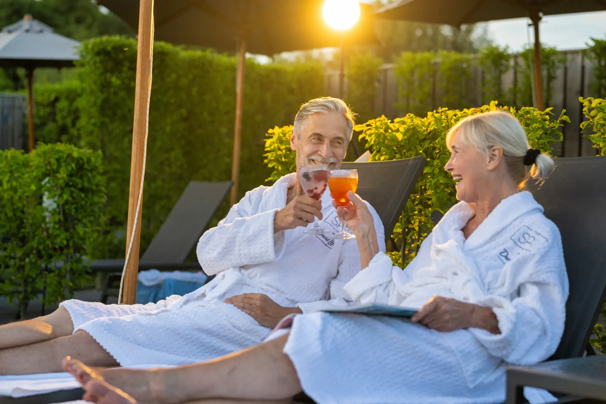 A couple enjoying drinks on the pool loungers