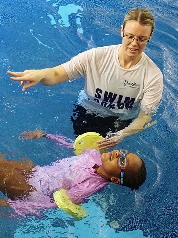 A girl having a swimming lesson with an instructor