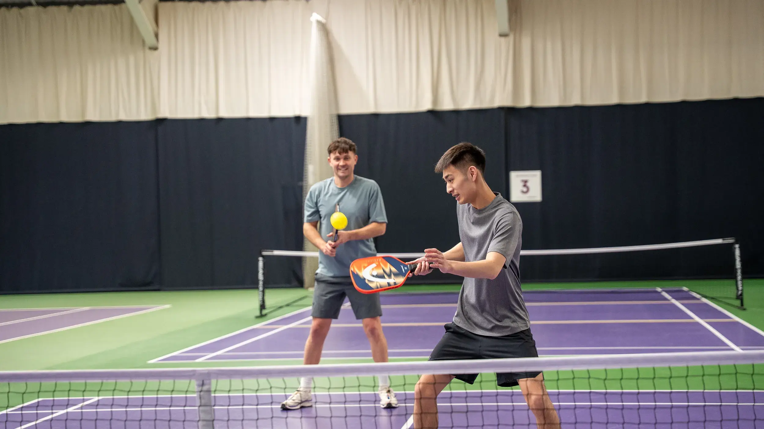 Two boys playing pickleball