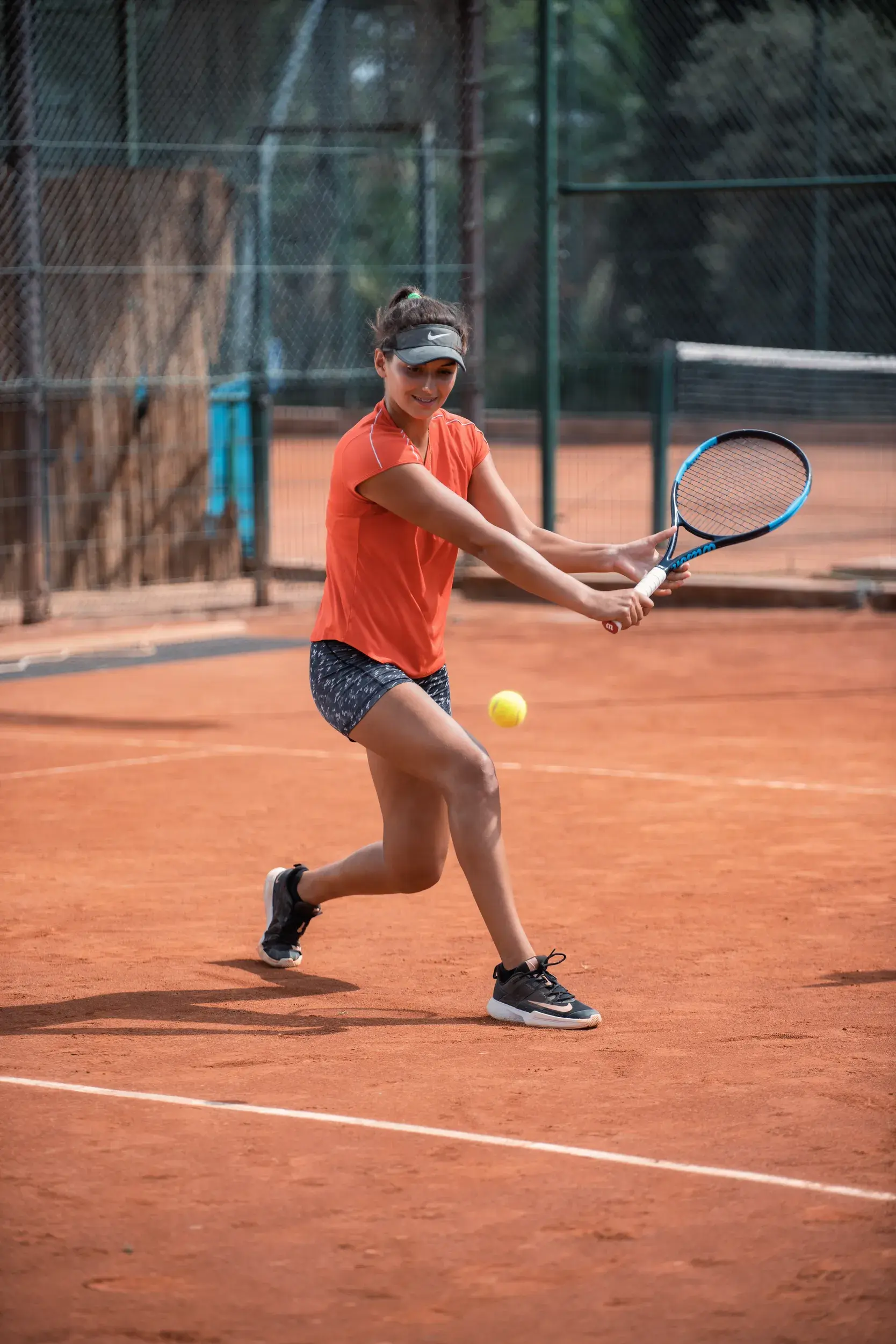 A woman playing tennis on an outdoor court