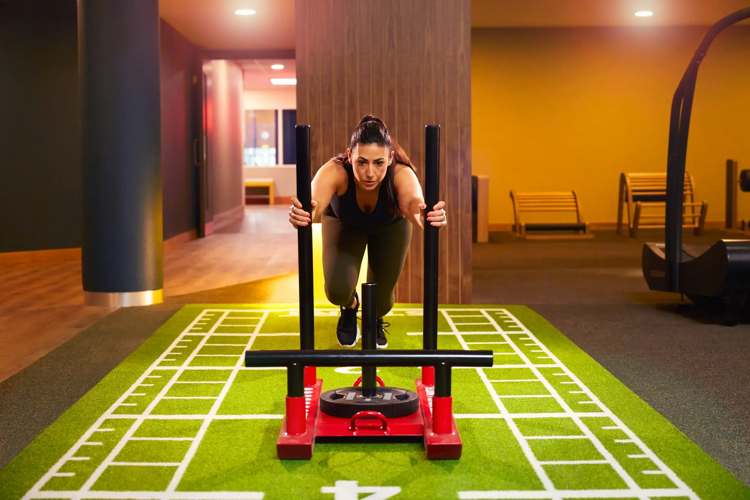A woman exercising using a push sled