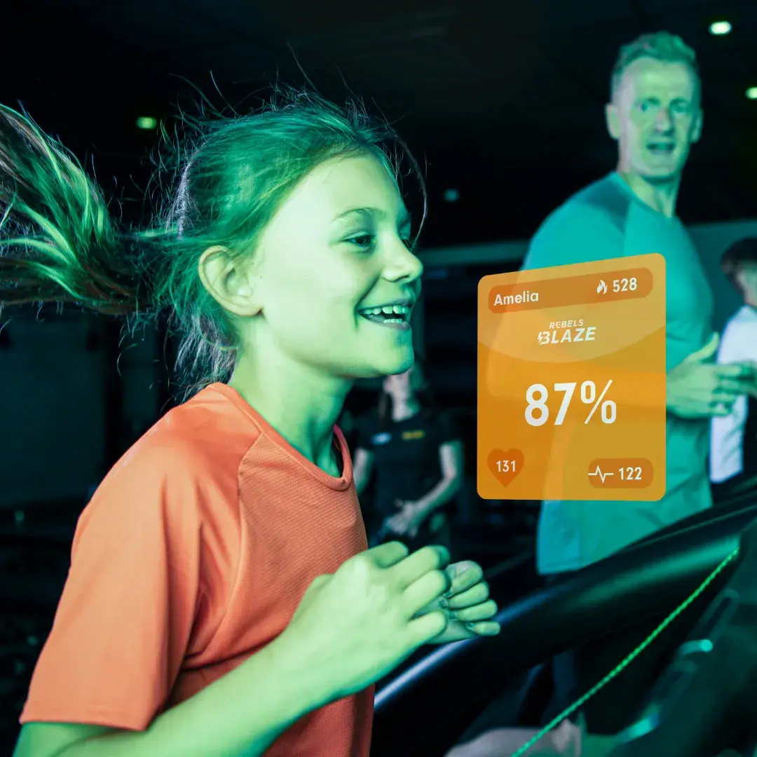 A young girl running in a Blaze class, with a graphic showing stats about her workout