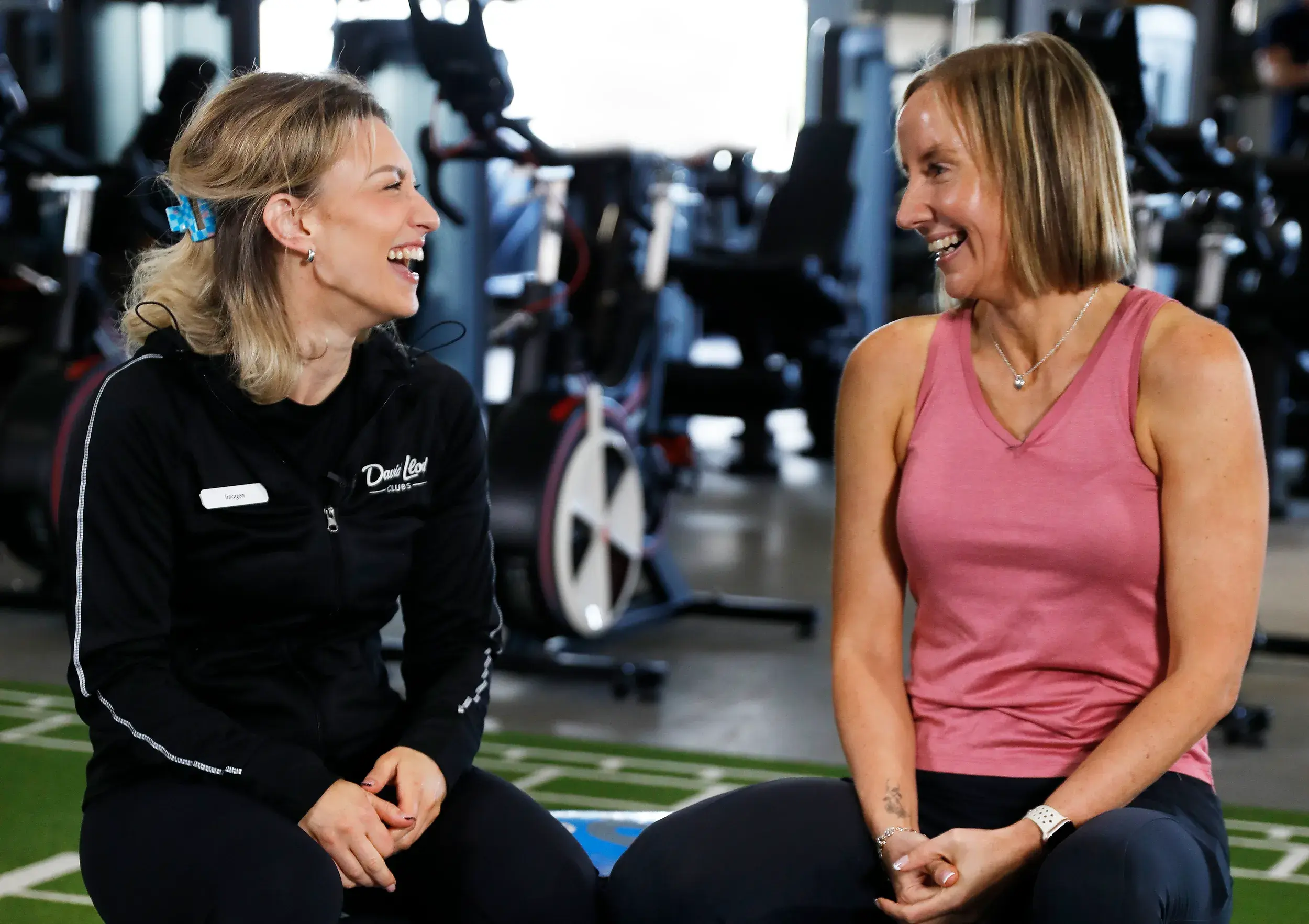 A woman smiling as she chats to her personal trainer