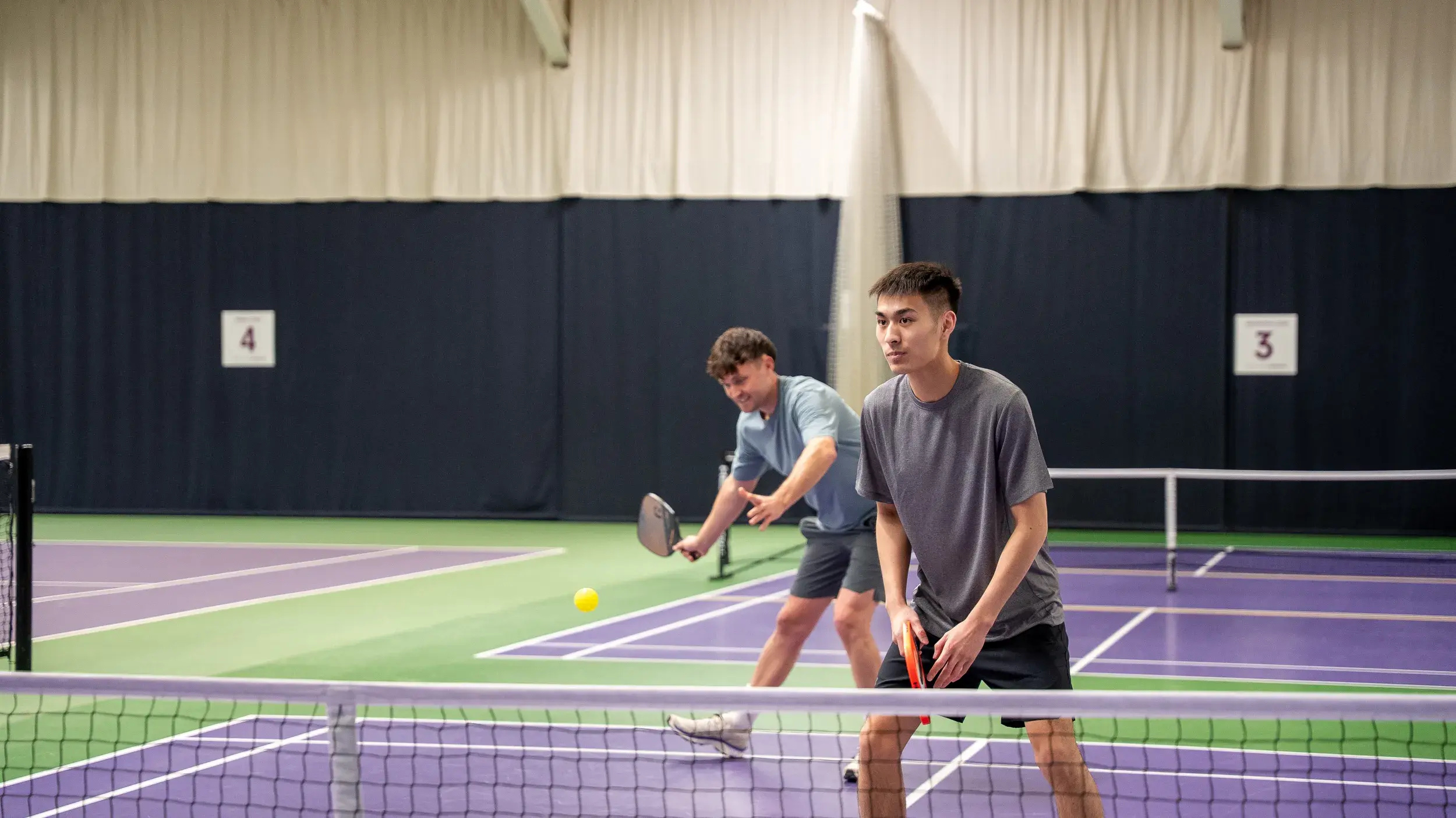 Two people playing pickleball