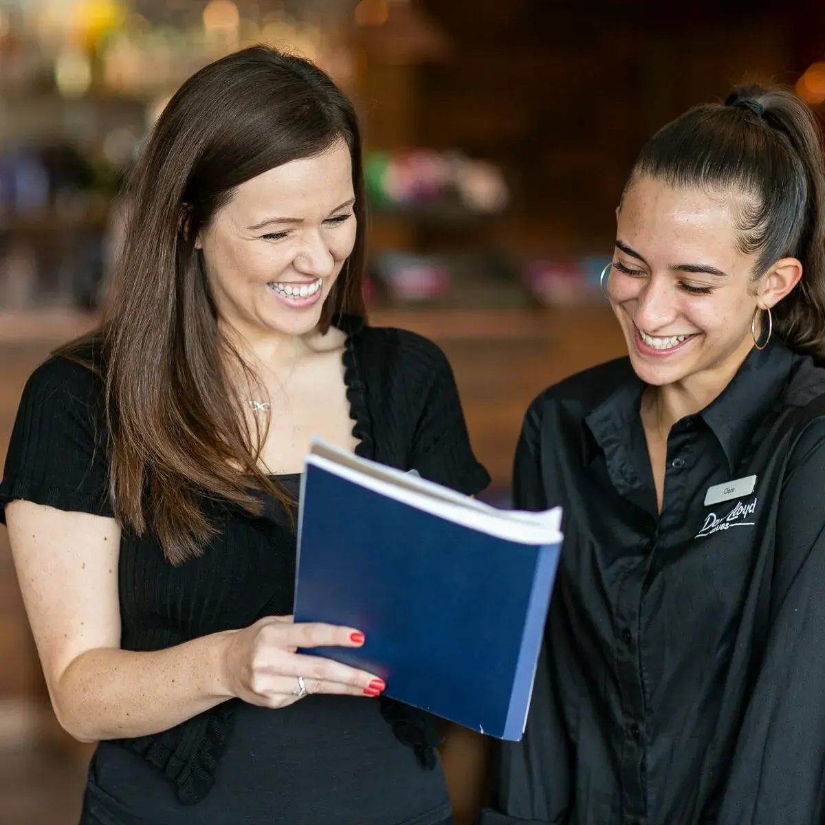 Woman showing a notepad to a colleague