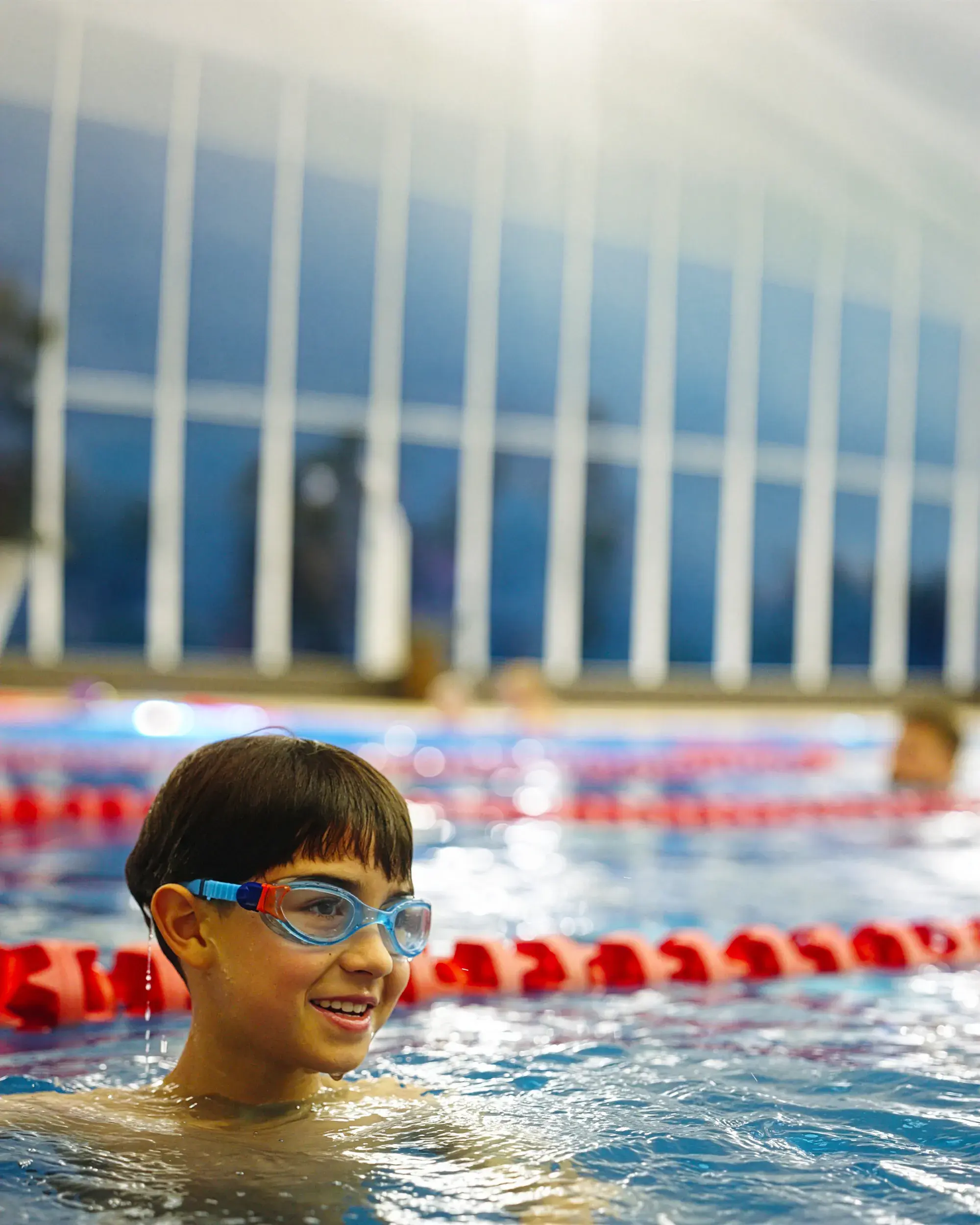 A young boy in the pool in swimming goggles