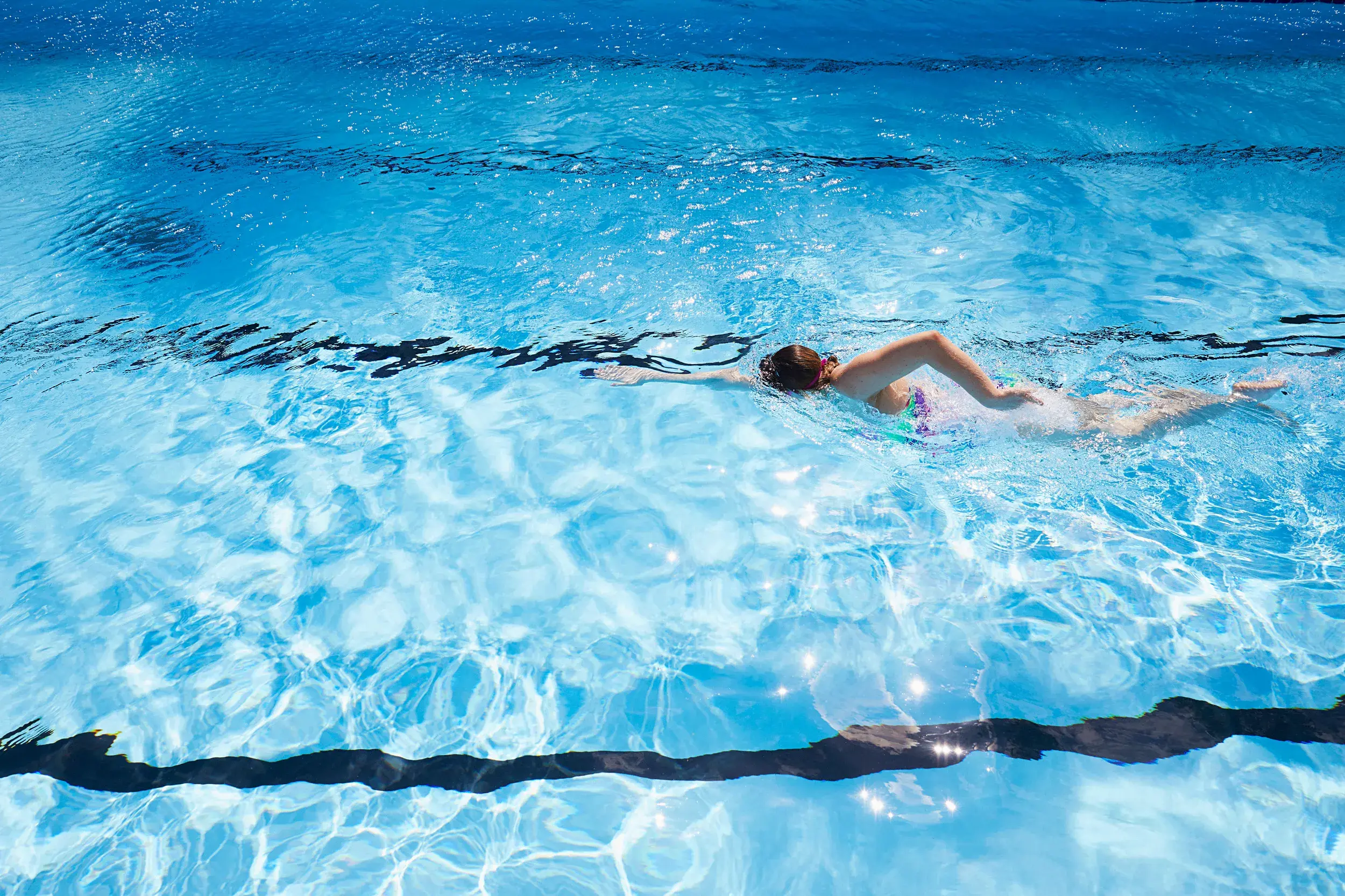 A woman swimming in an outdoor pool