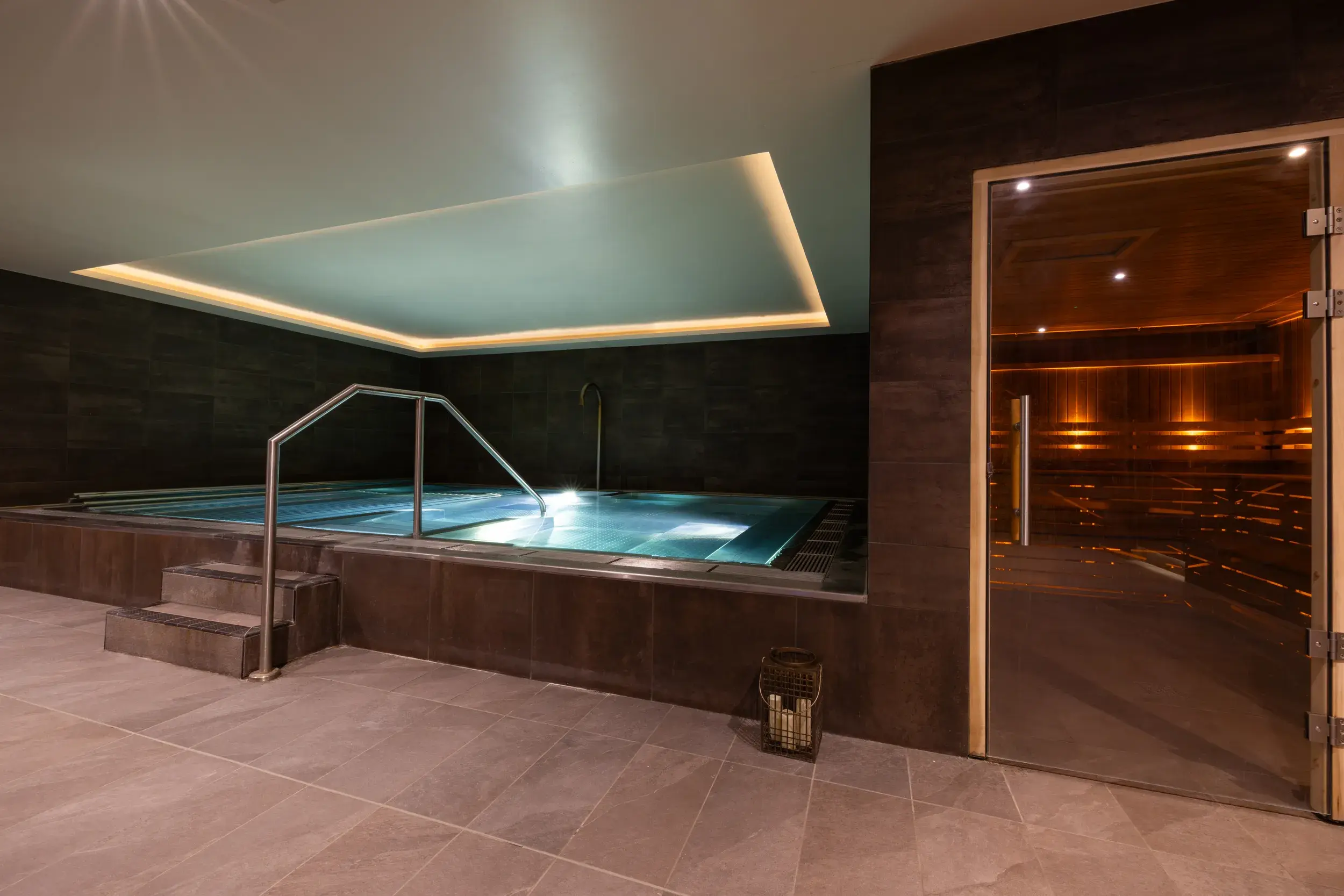 A woman reclines blissfully in a spa pool overlooking a sunny afternoon