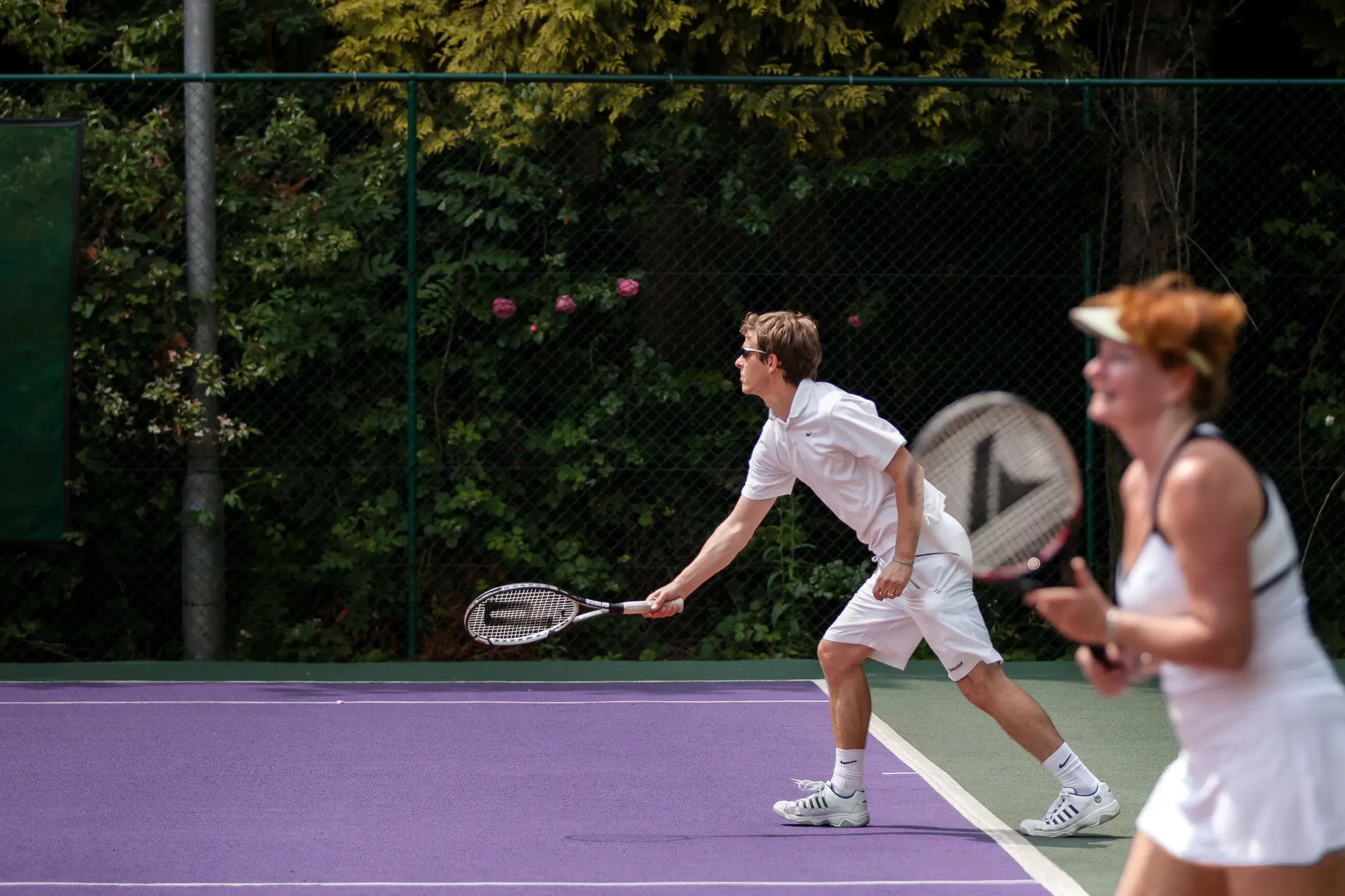 Two people playing in a doubles tennis match