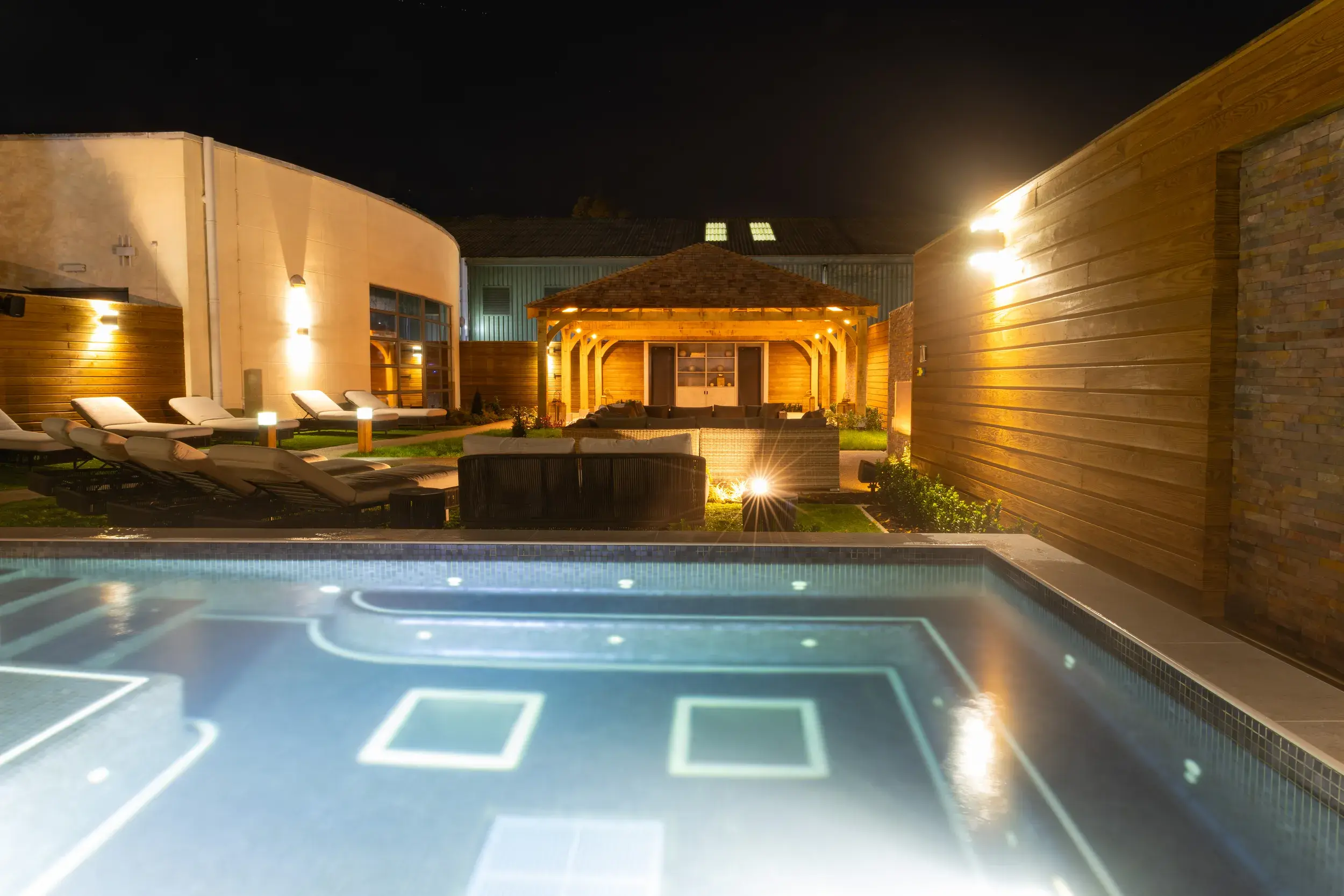 The pool and loungers at night in the Spa Garden