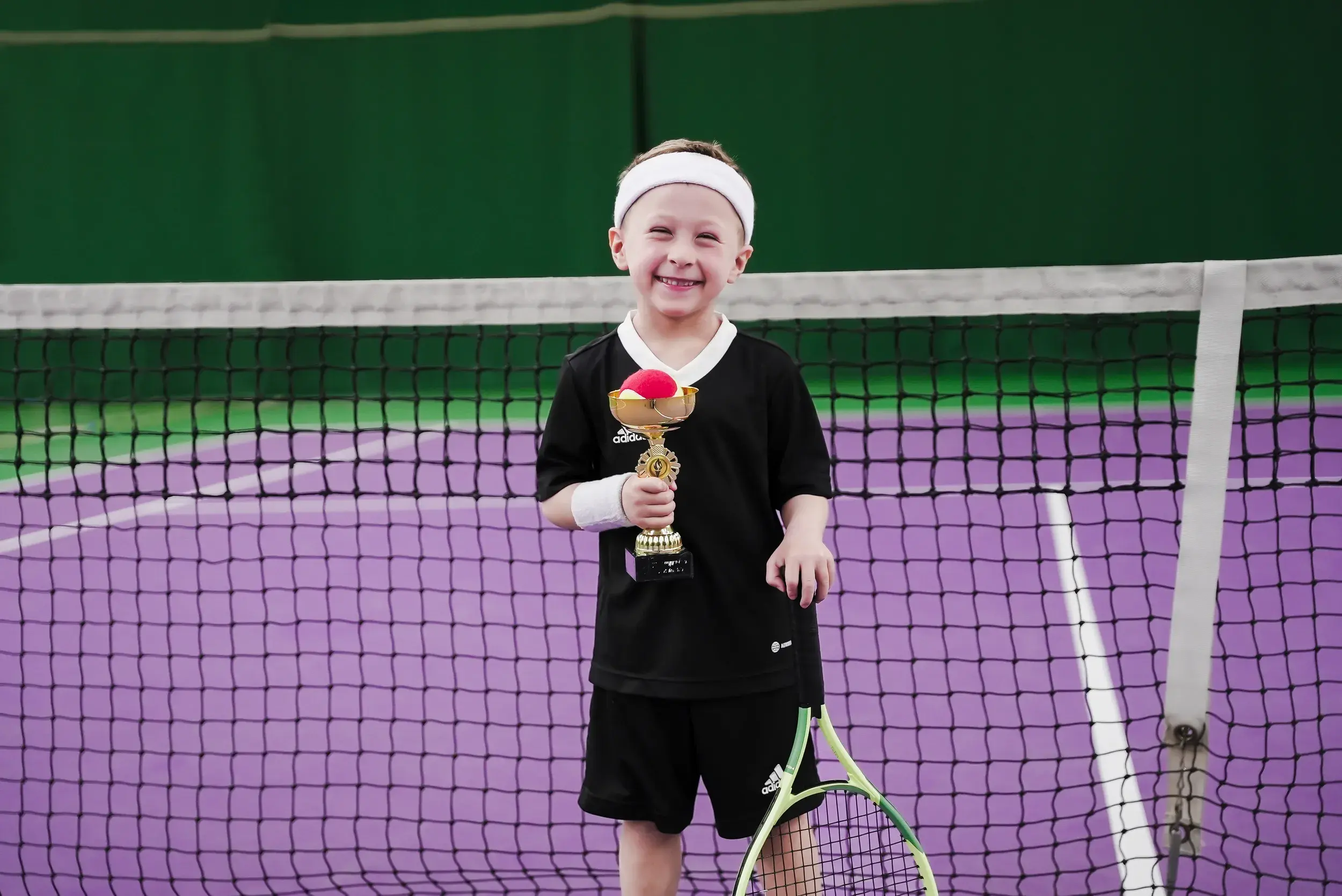 A young boy holding a tennis racquet