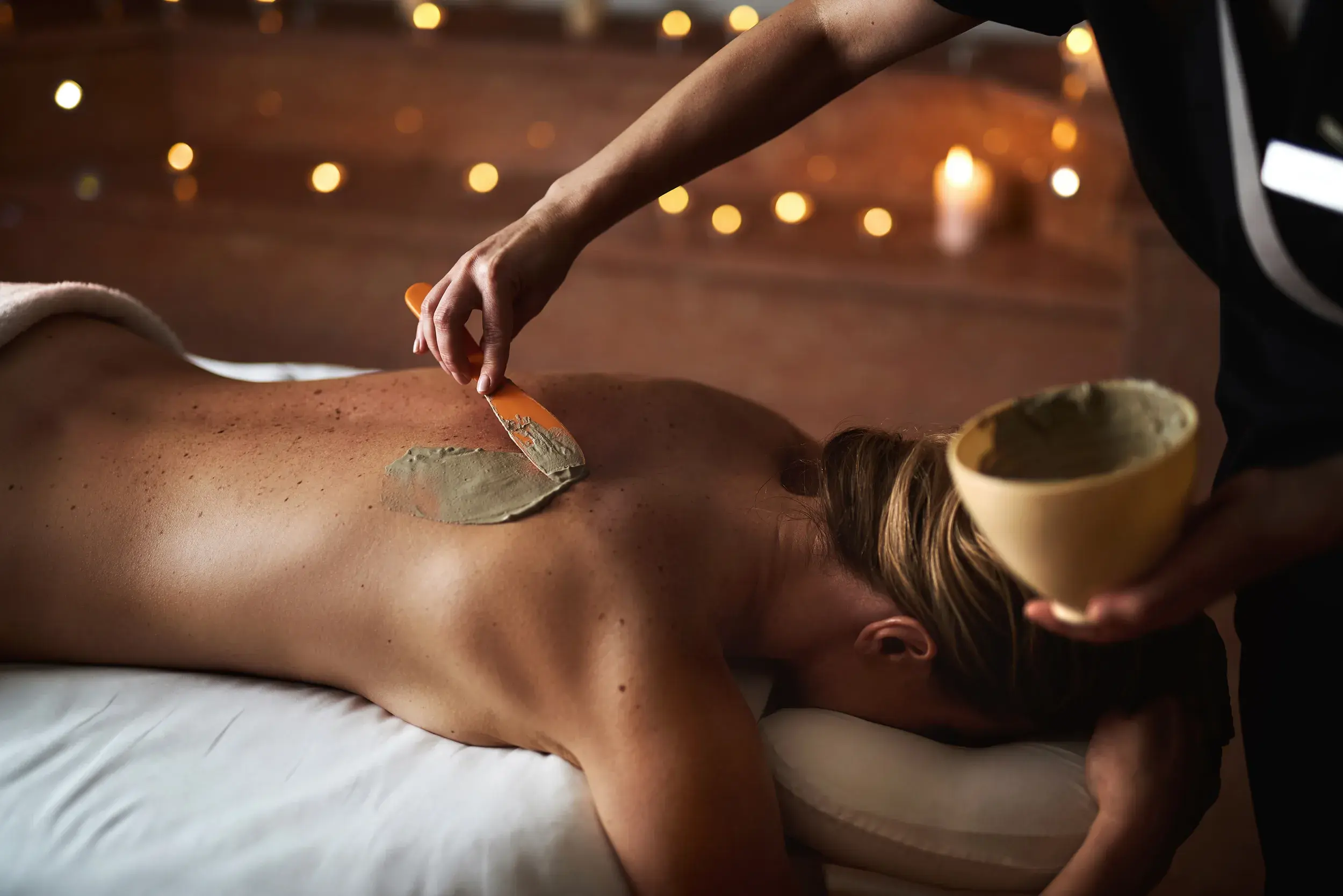 A woman receiving a mud treatment