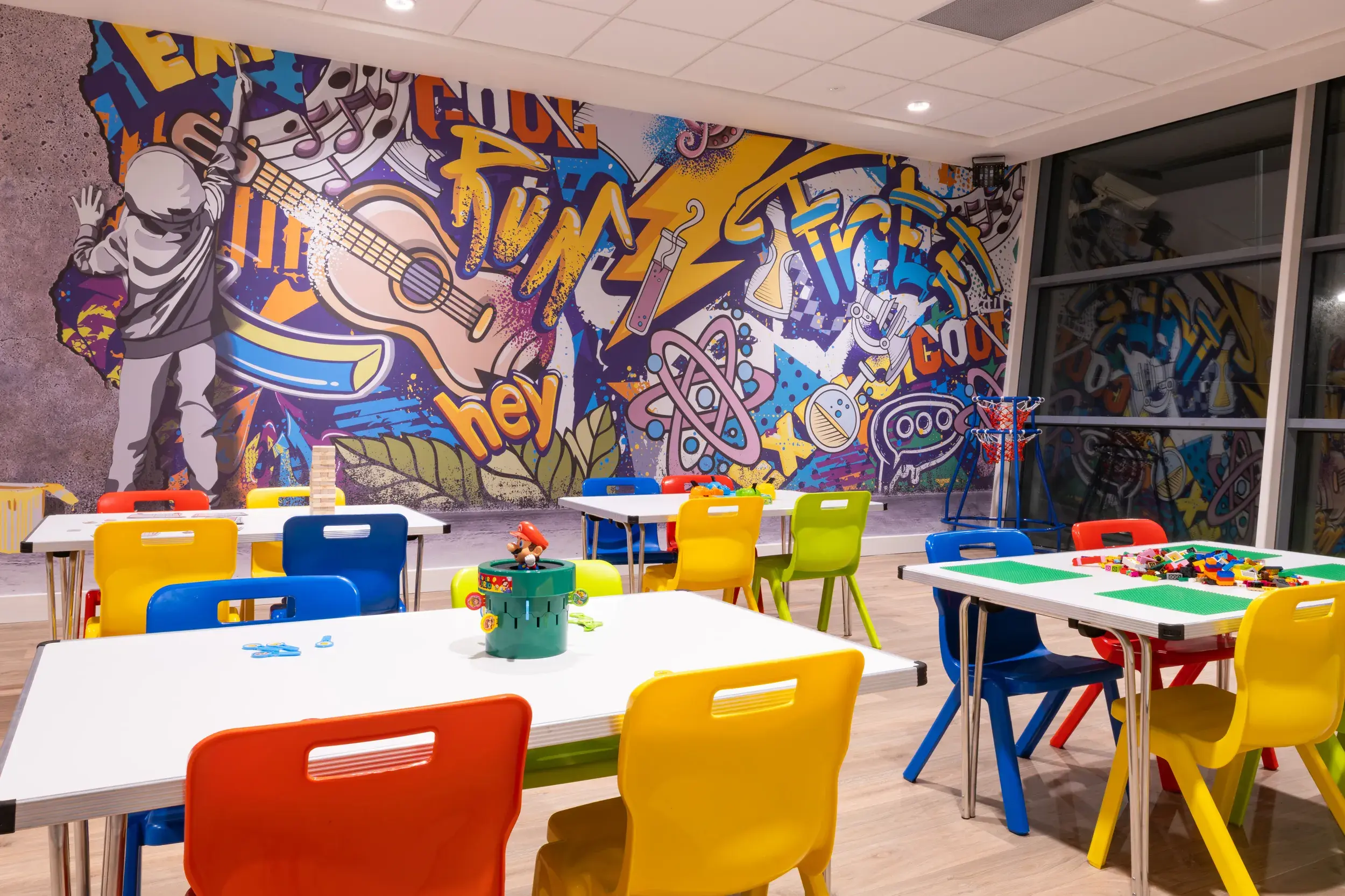 Kids area showing colourful chairs and a graffiti wall