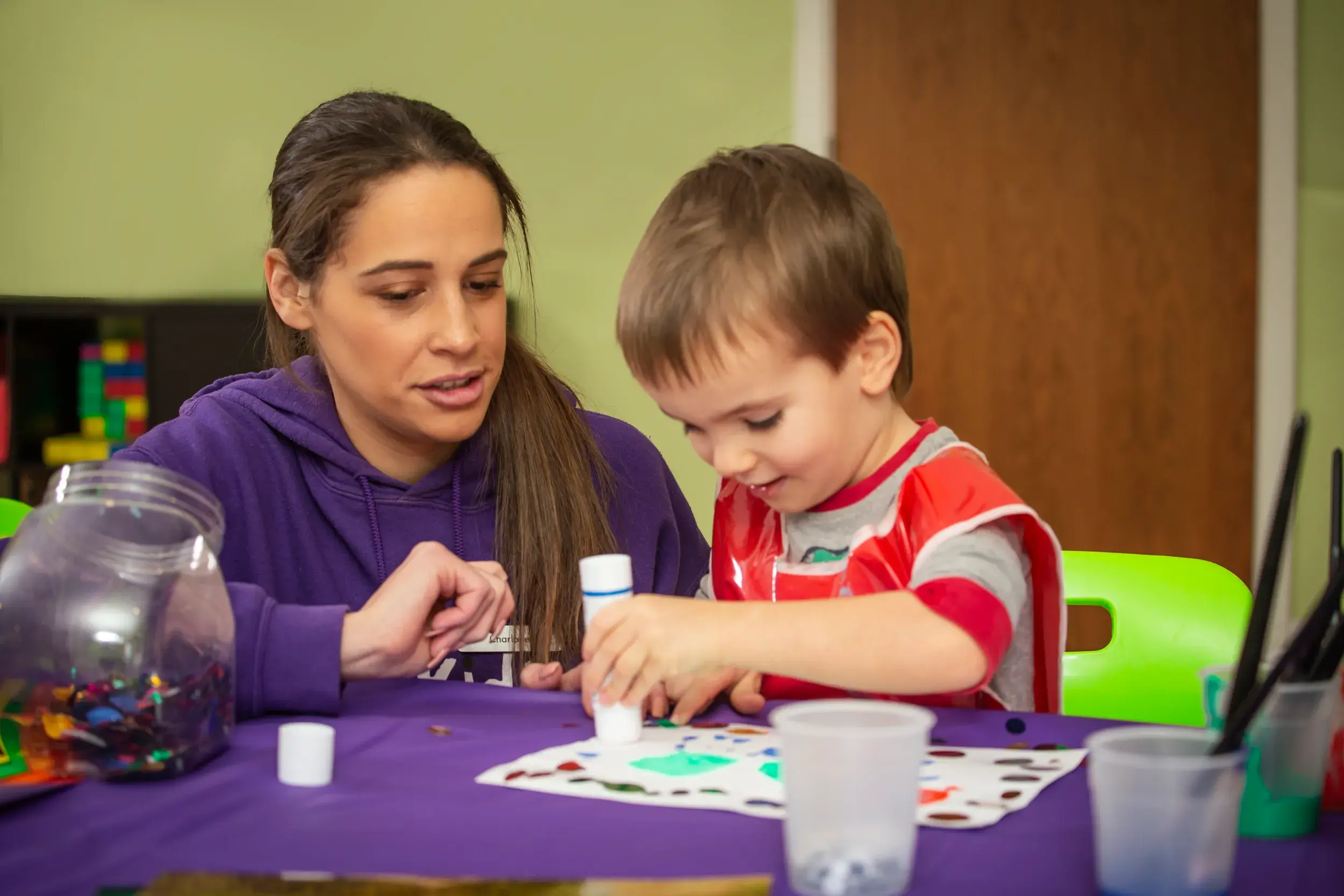A baby with a DL Kids team member in the creche