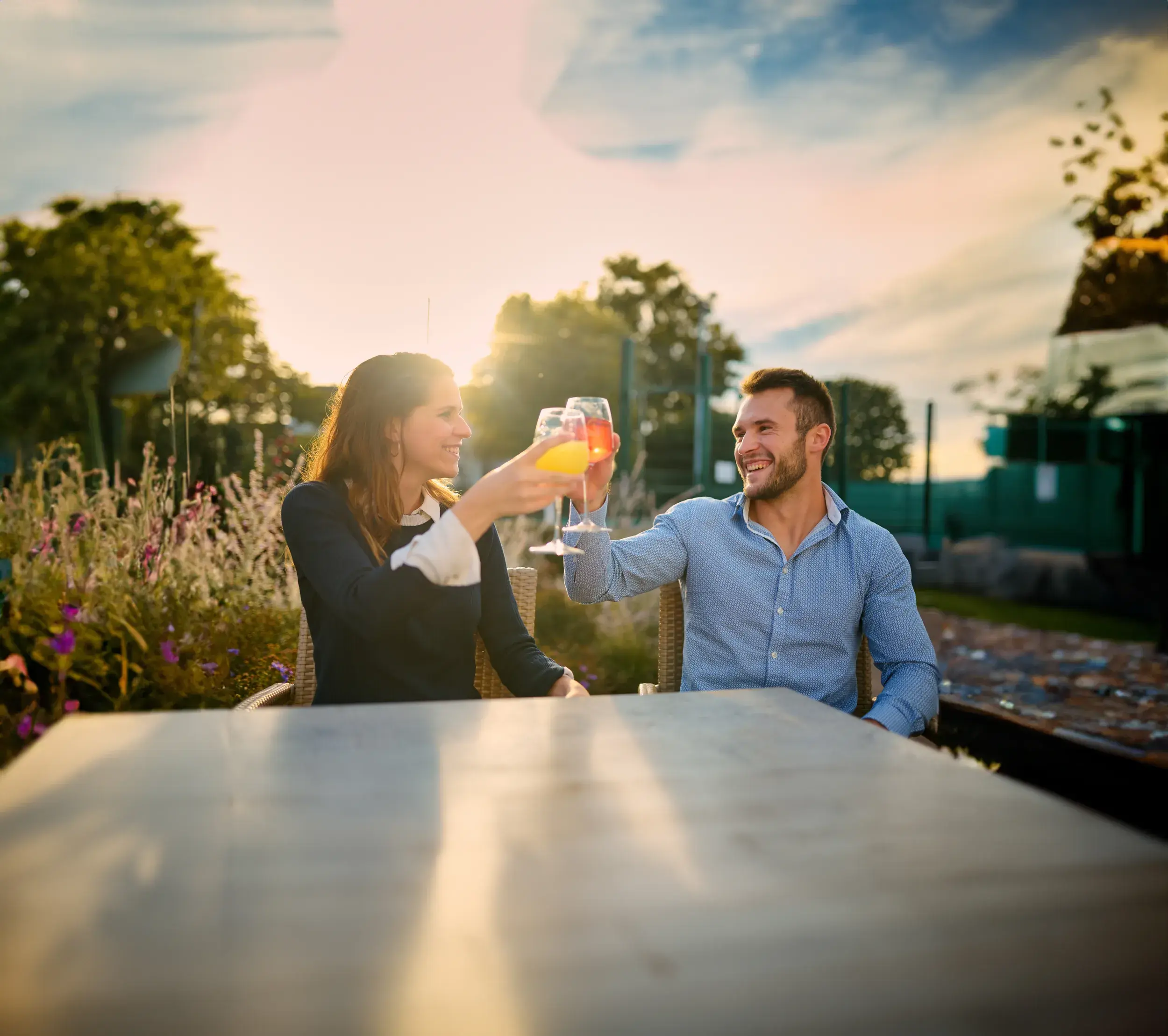 A man and a woman enjoying a drink on the outdoor terrace