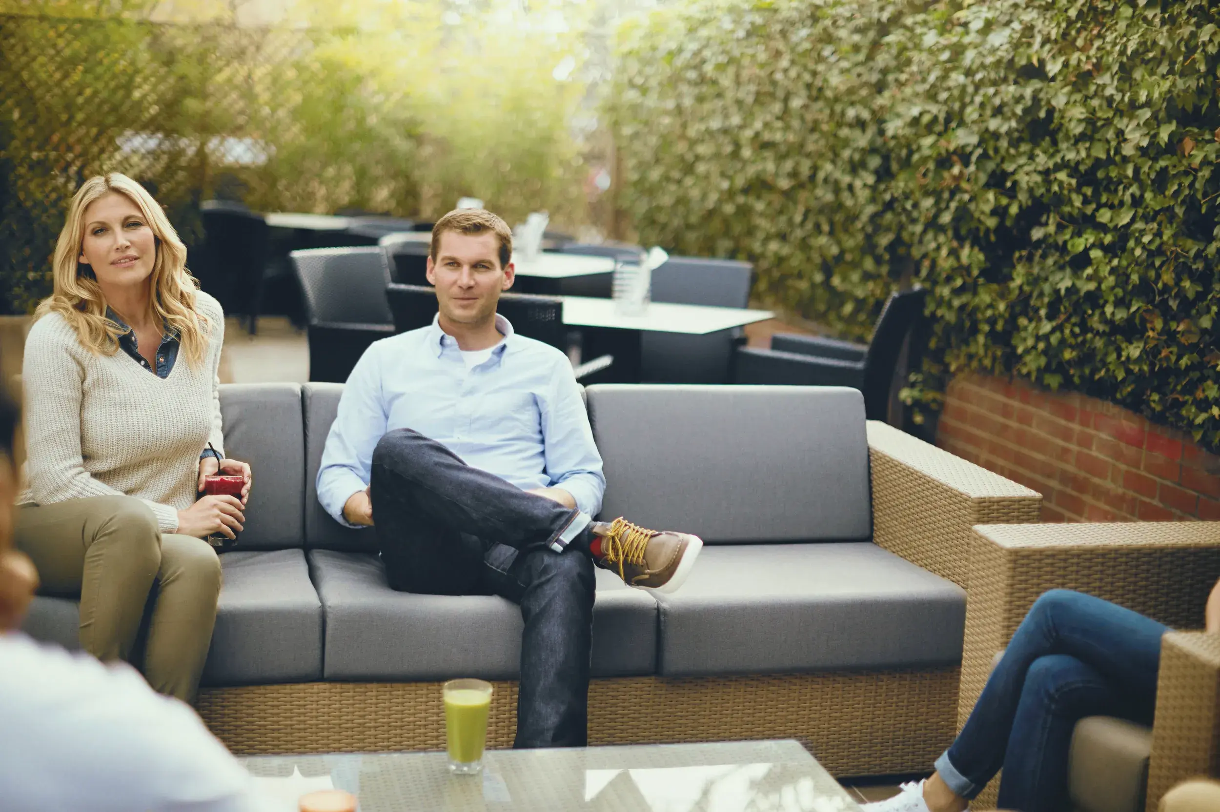 A man and a woman enjoying a drink on the outdoor terrace