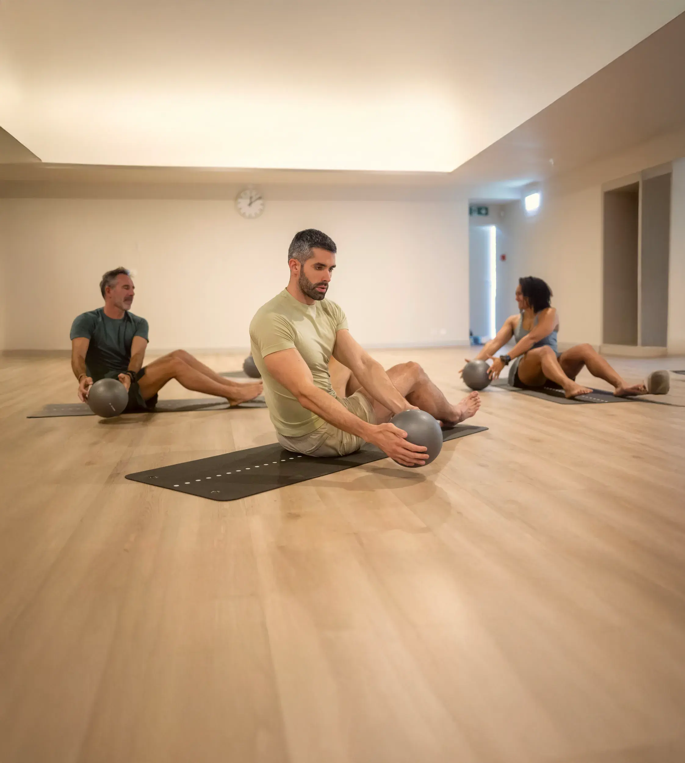 A Pilates class stretching with weighted balls