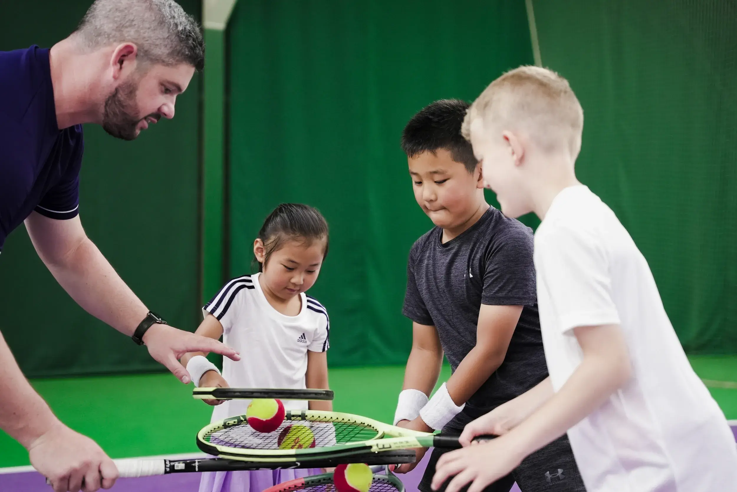 Children holding tennis racquets