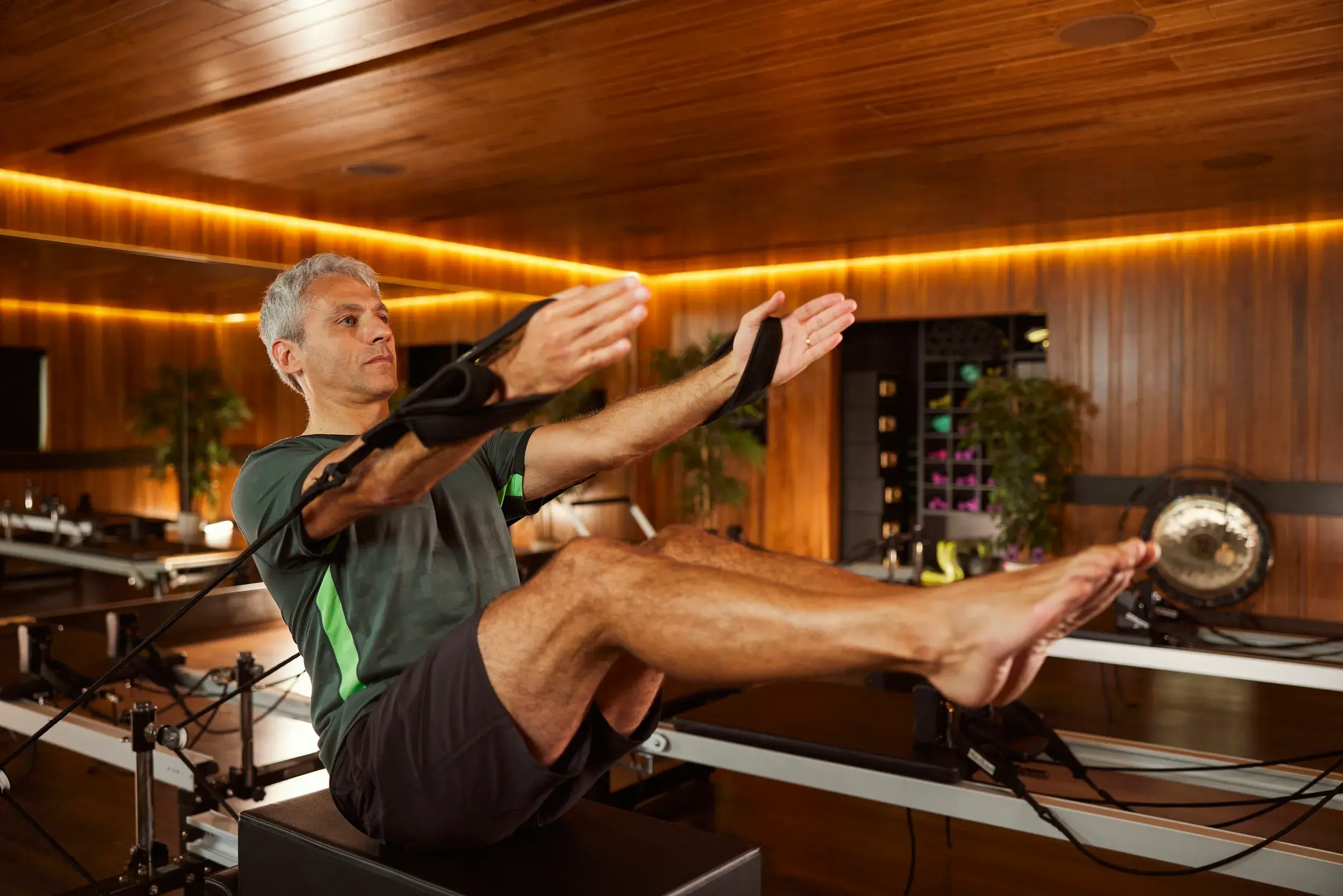 Man on a Reformer Pilates machine.