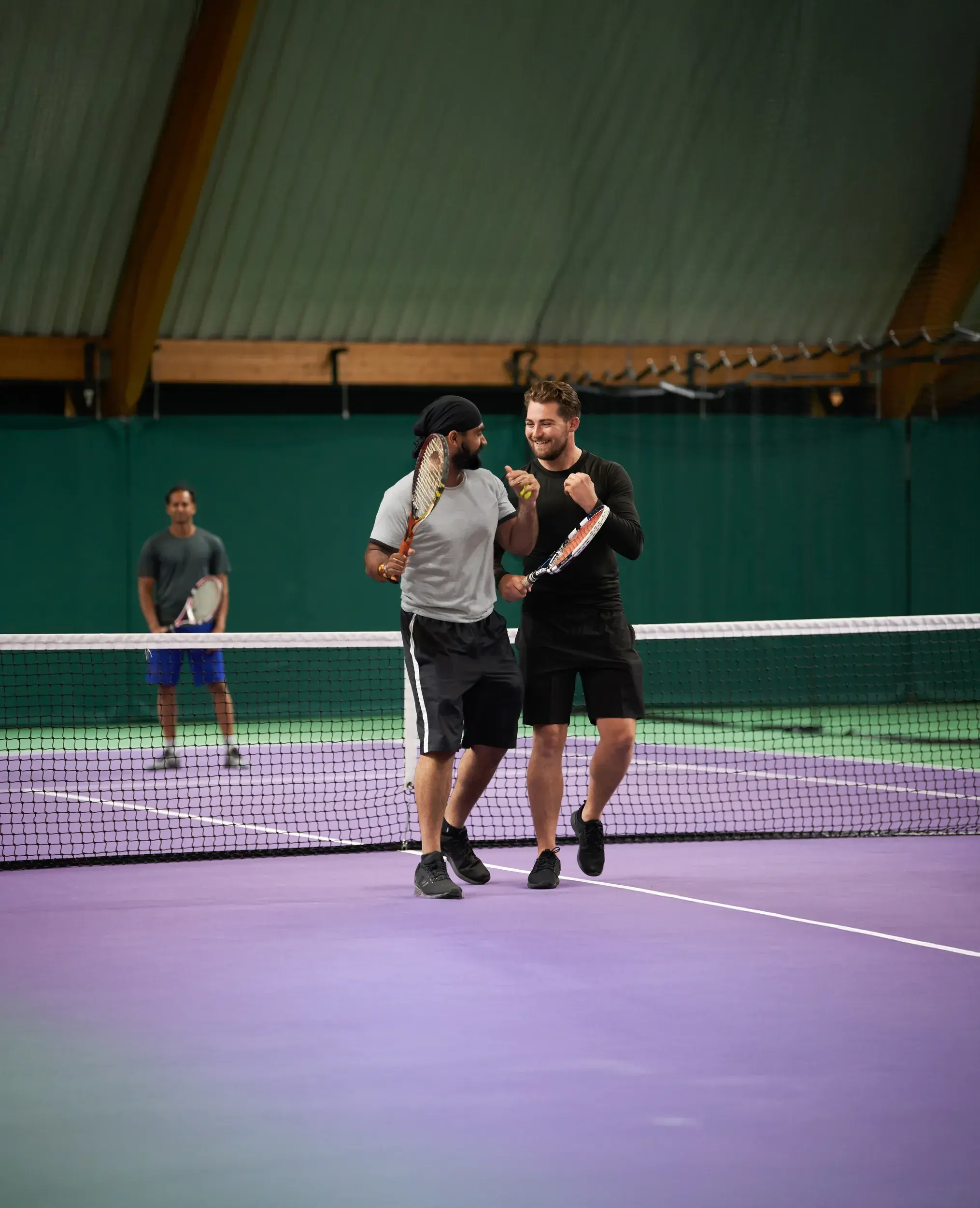 People playing on an indoor tennis court