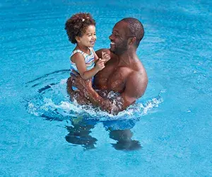 A man and baby in the pool