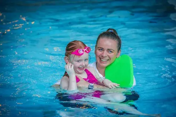 A young girl and swimming coach
