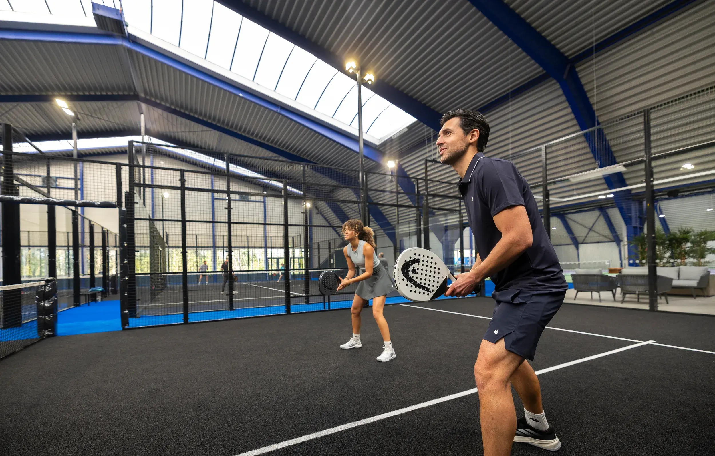 2 people playing indoor Padel