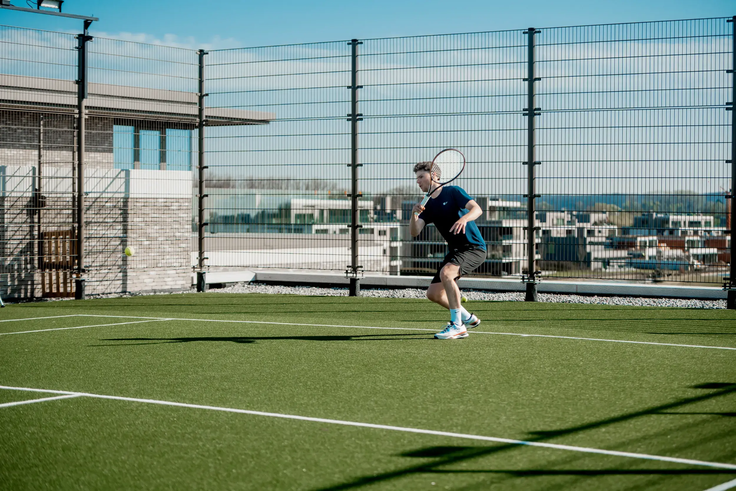 Two men on the outdoor rooftop tennis court