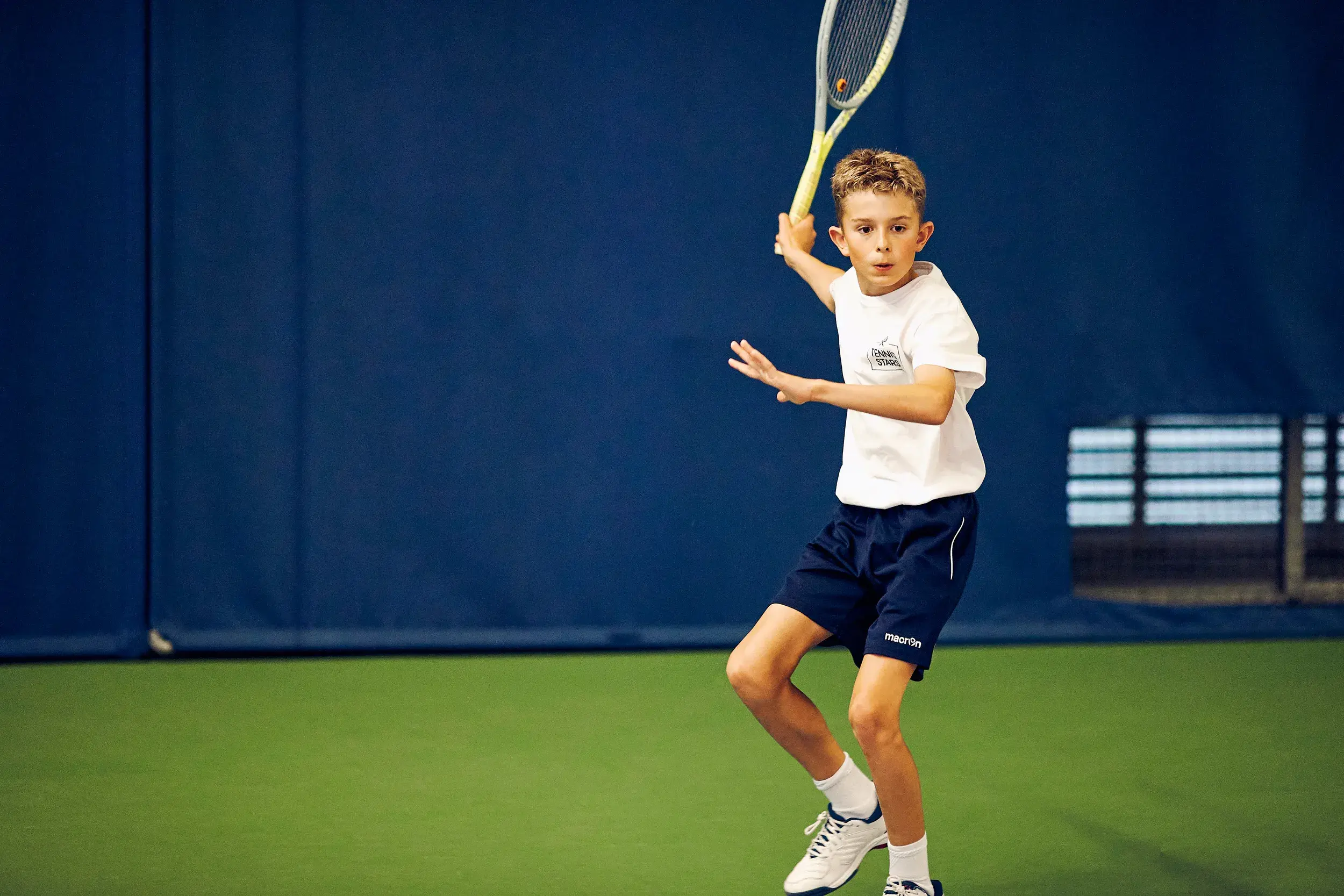 A young boy playing tennis
