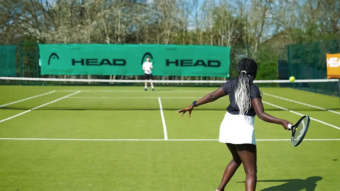 A woman playing tennis on an outdoor court